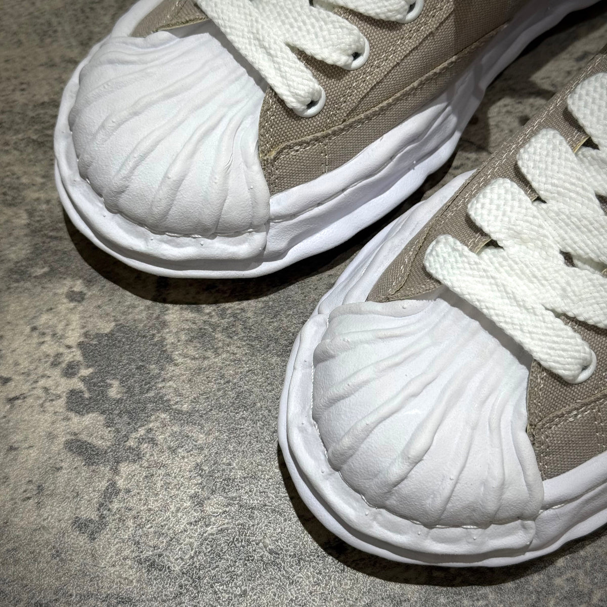 Close-up of MMY BLAKEY OG Canvas sneakers in gray with unique shell-like toe design and white laces.