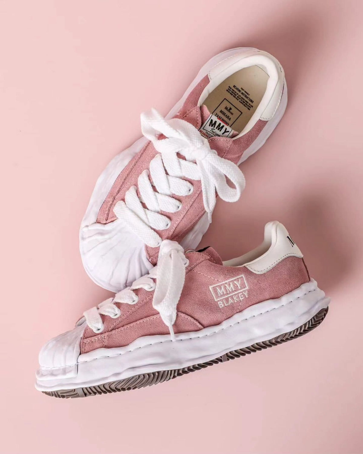 MMY Blakey Suede Low - Pink A17FW745 displayed on a pink background, showcasing its stylish design and features.