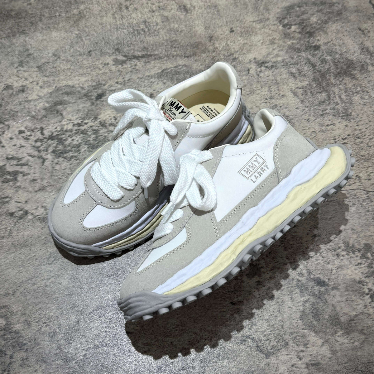 MMY Larry Leather Low - White sneakers with oversized design on a textured surface.