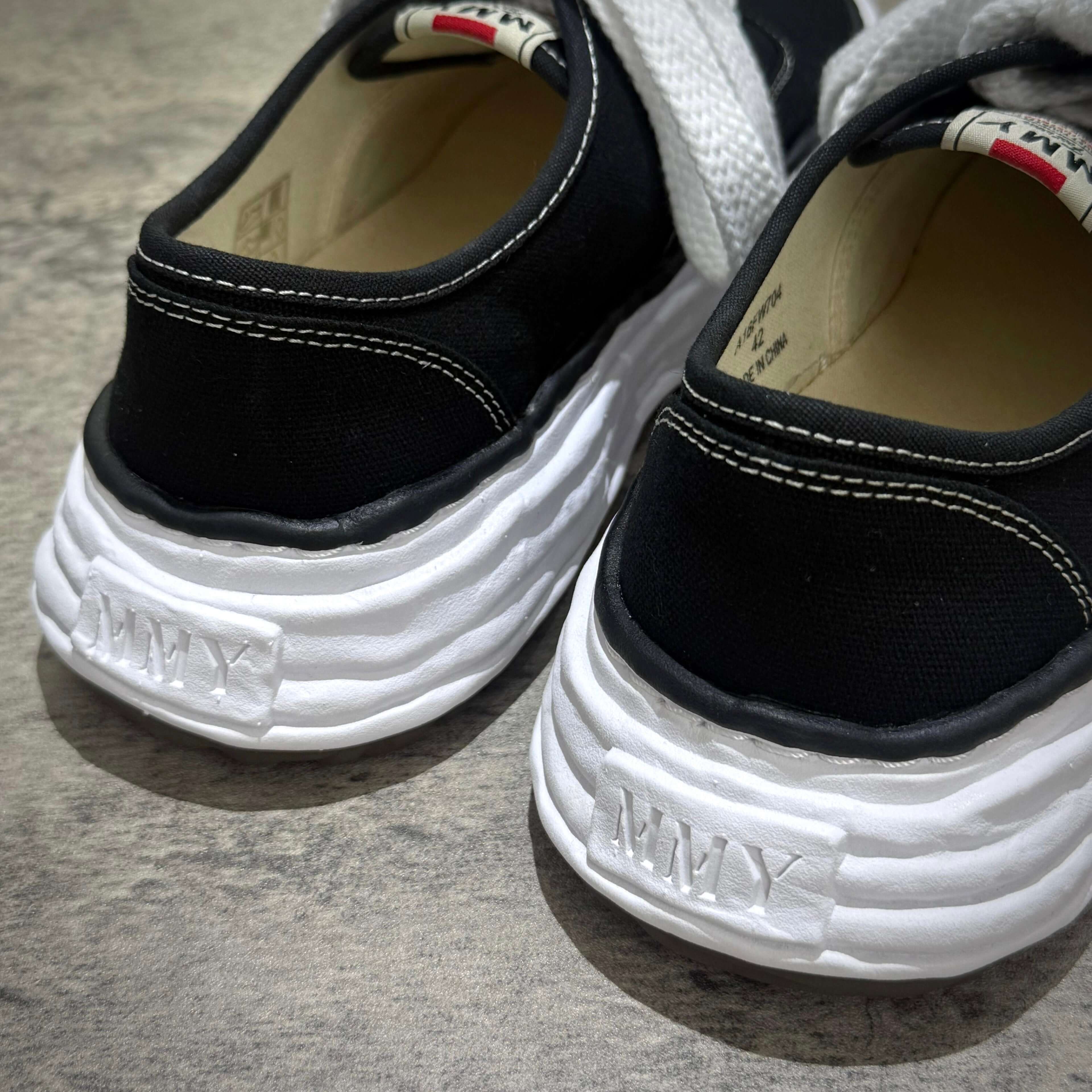 Detail of MMY Baker26 Canvas Low - Black shoes showing the rear design and stitching.