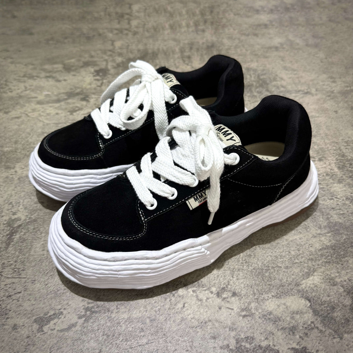 MMY Oliver Suede Low - Black shoes featuring a stylish black suede design with white details and laces.
