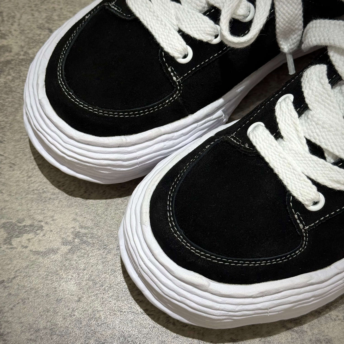 MMY Oliver Suede Low - Black close-up view showcasing black suede upper and white laces.
