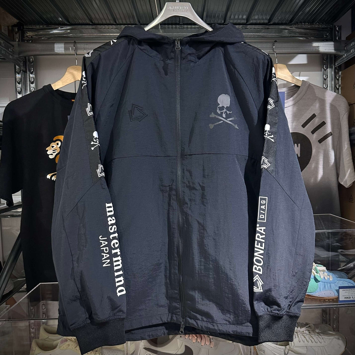 Mastermind Japan x Bonera Stretch Anthem Jacket displayed on a hanger, showcasing the front design with logos and details.