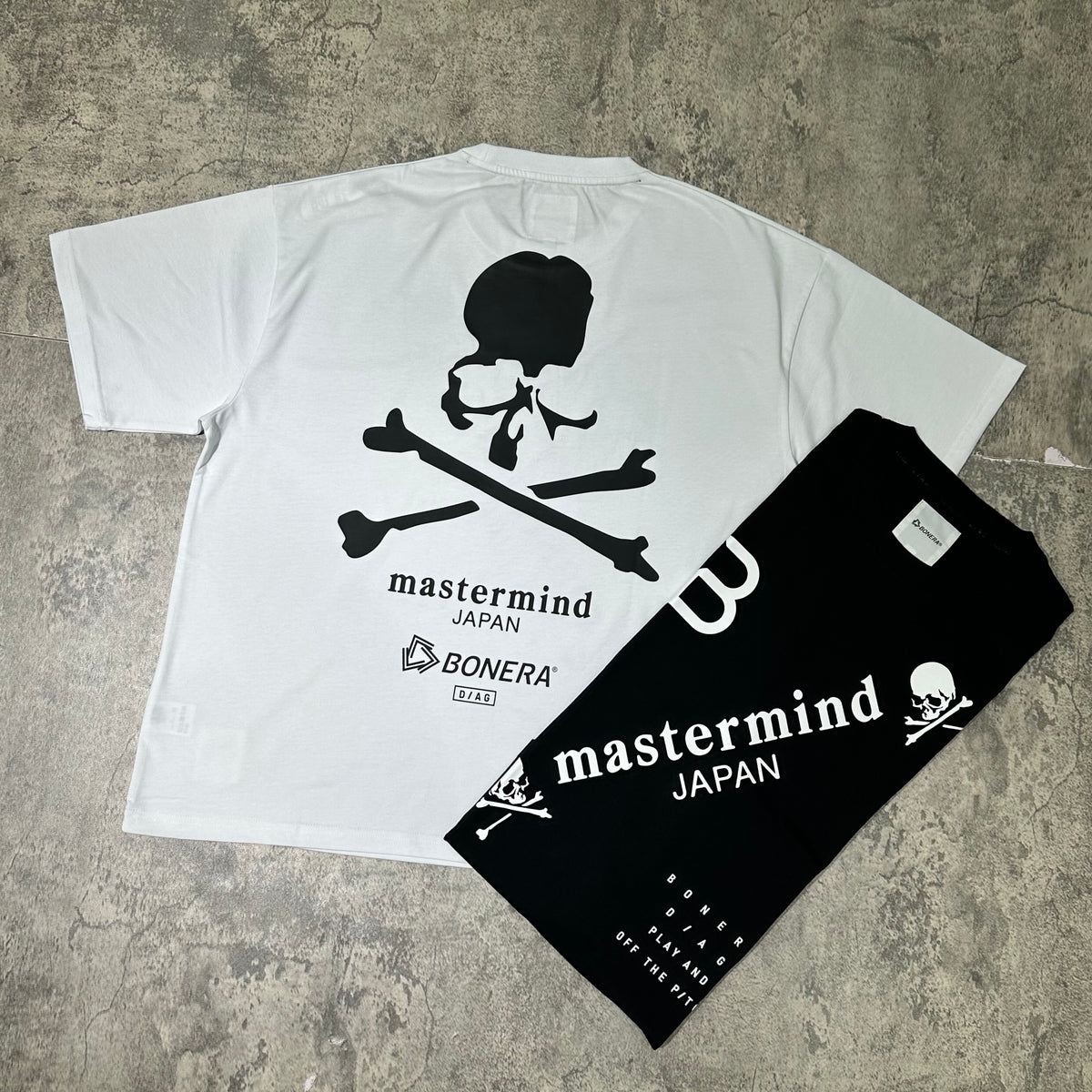 Mastermind Japan x Bonera Tee featuring skull and crossbones design on white and black shirts.