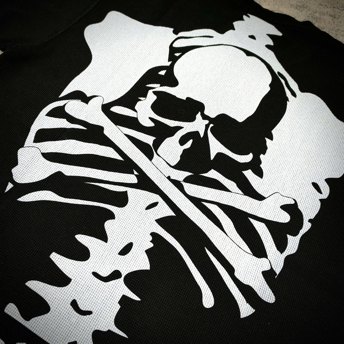Mastermind World x Vanson Regular Fit Tee featuring a skull and bones design on a black background.