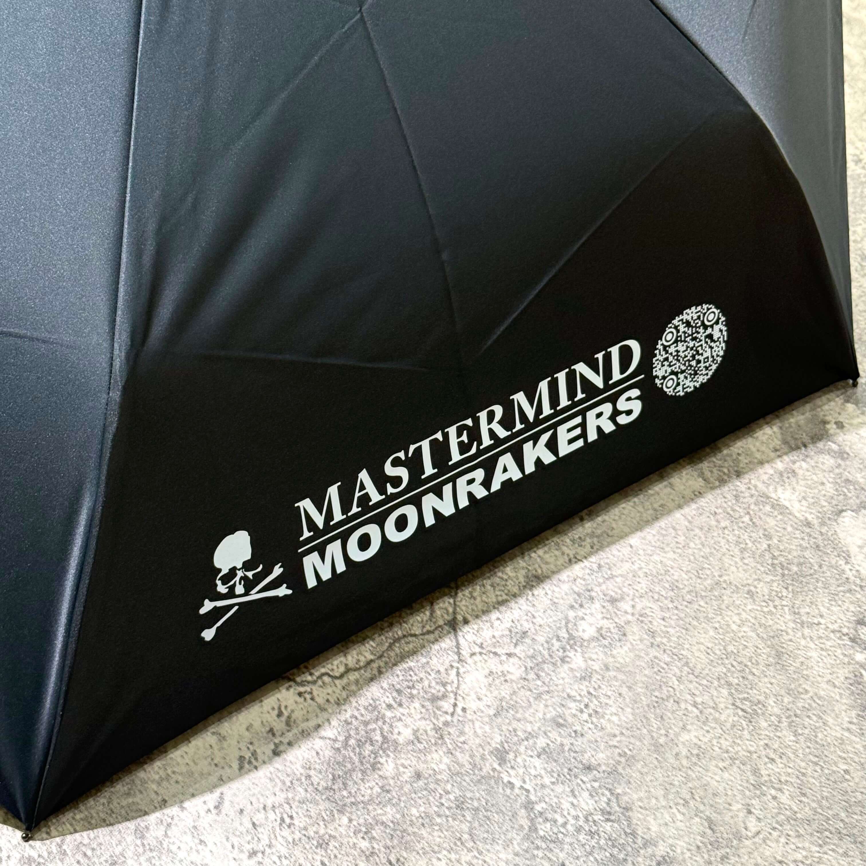 Mastermind Japan Moonrakers Umbrella displaying logo and design details on a black canopy.