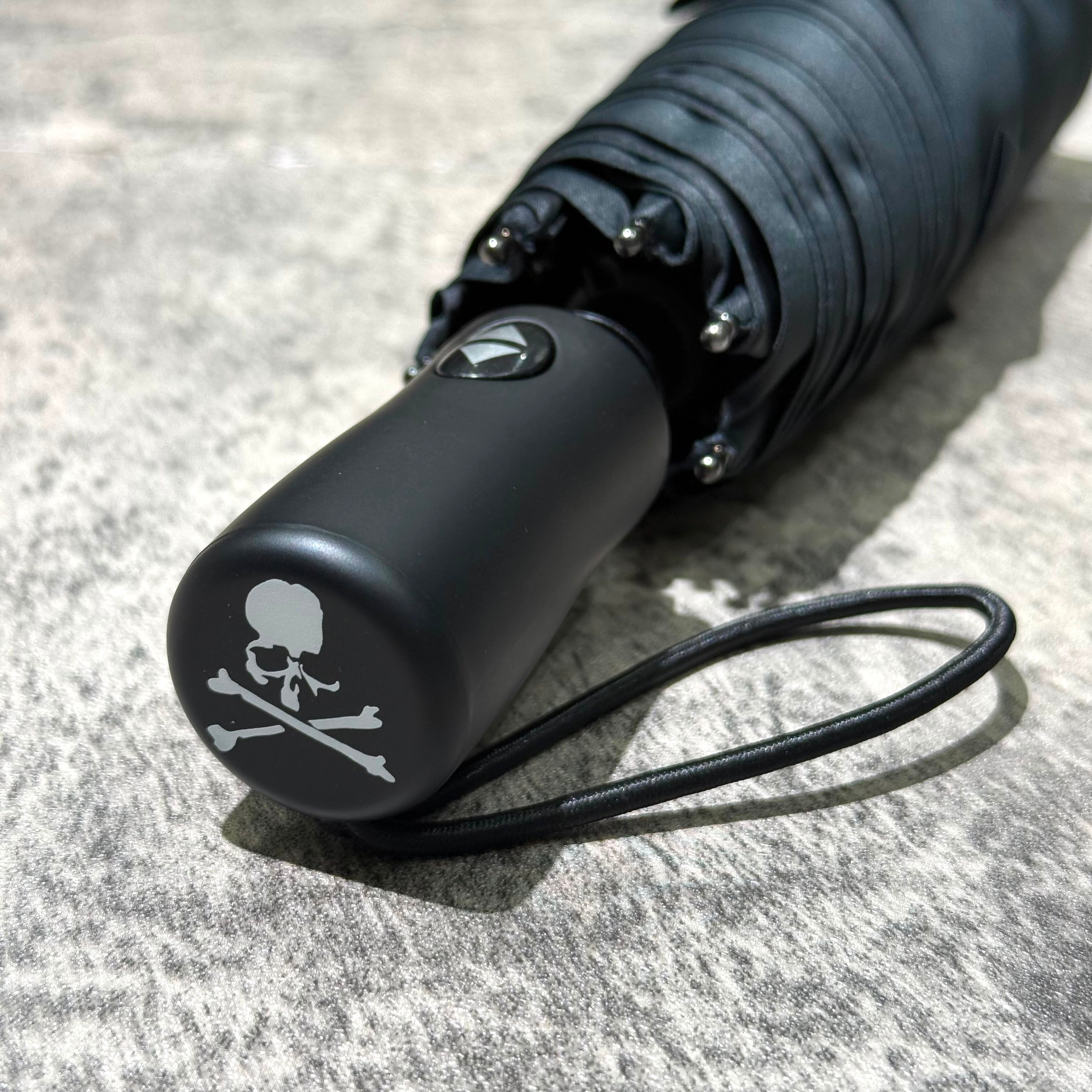 Mastermind Japan Moonrakers Umbrella handle featuring skull and crossbones design, automatic open/close feature.