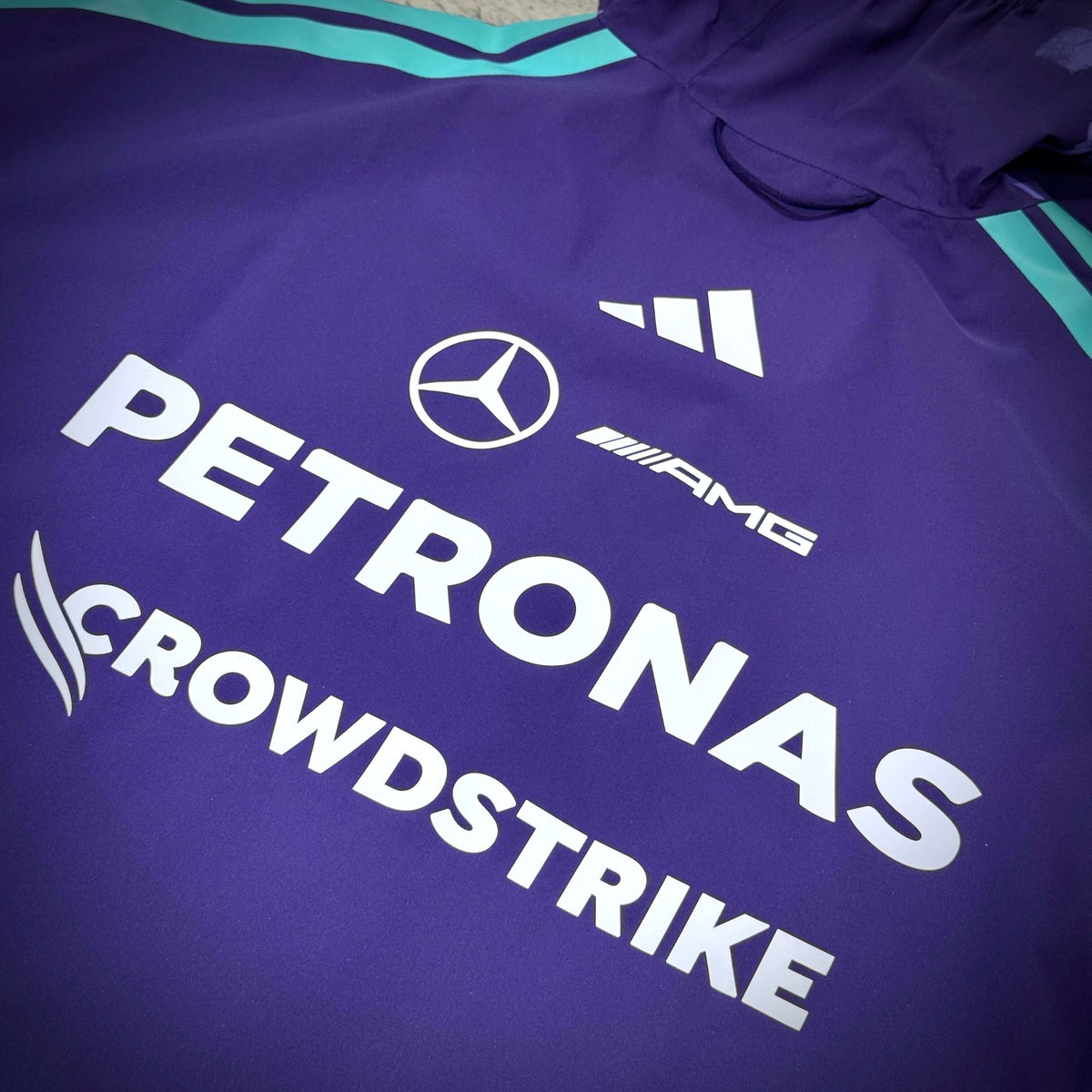 Close-up of the Mercedes-AMG Petronas Formula 1 Team Vanda Bloom Rain Jacket showing logo details.