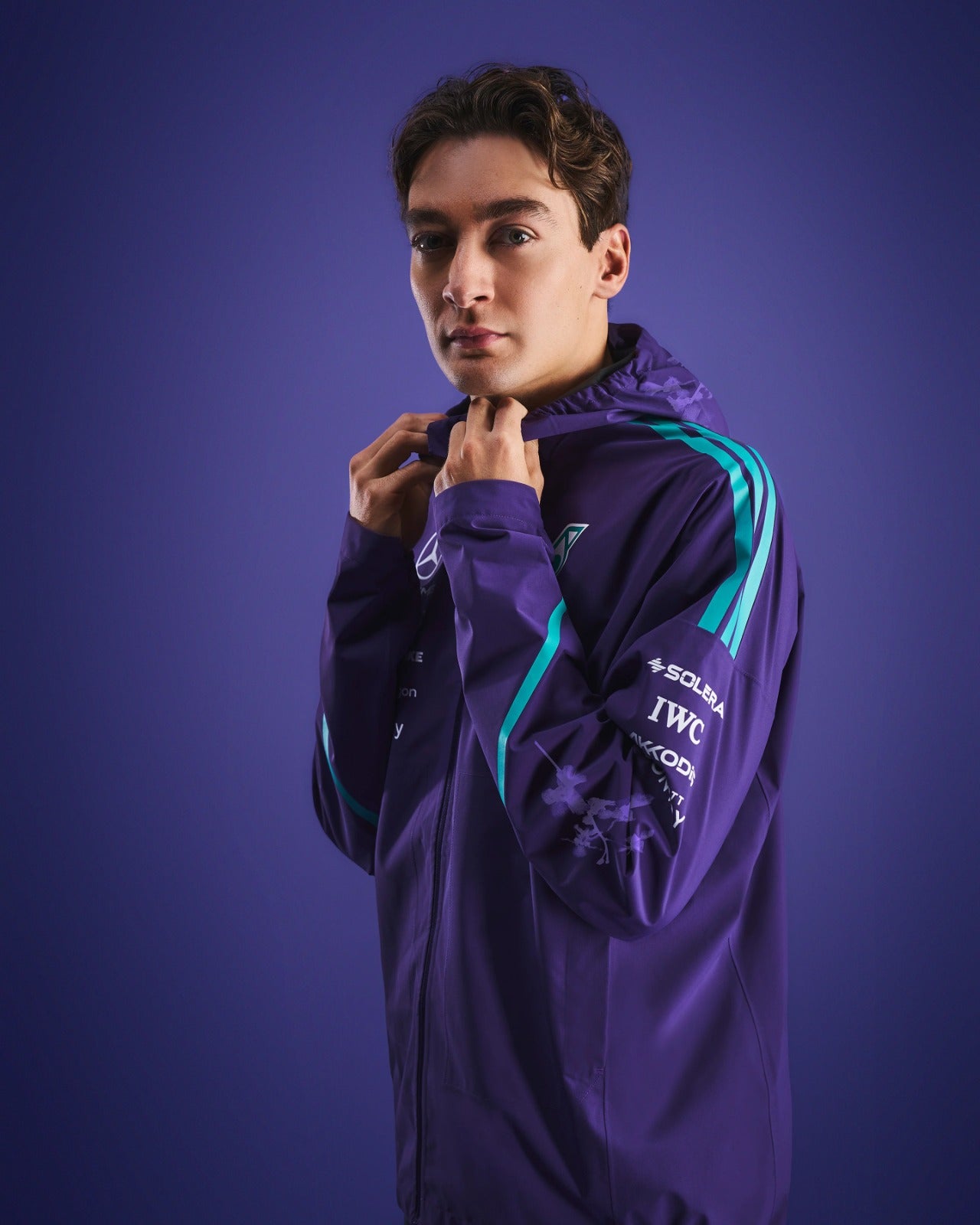 Model wearing the Mercedes-AMG Petronas Formula 1 Team Vanda Bloom Rain Jacket HZ9485 against a purple background.