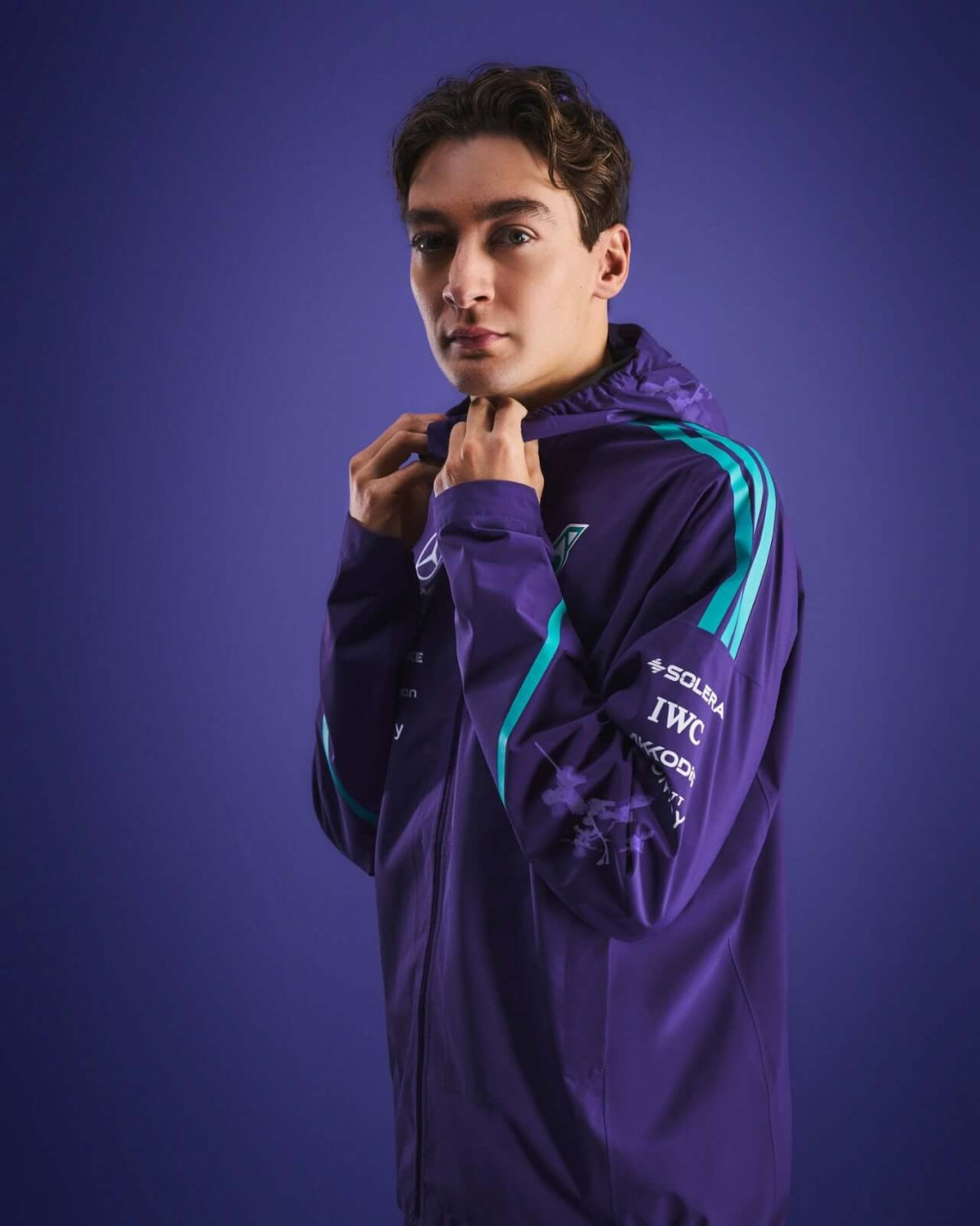 Model wearing the Mercedes-AMG Petronas Formula 1 Team Vanda Bloom Rain Jacket HZ9485 against a purple background.