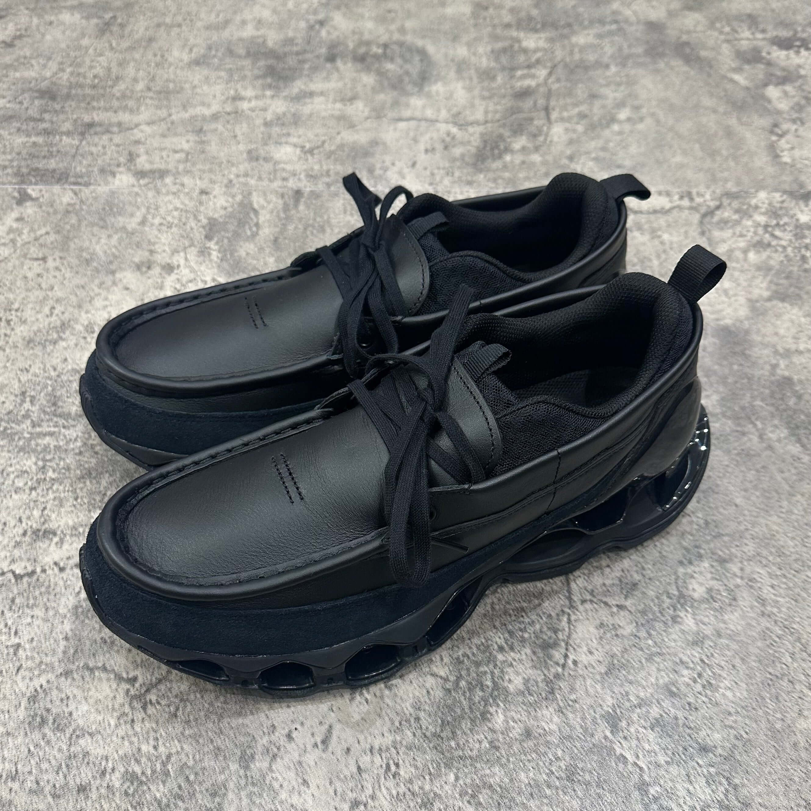 Mizuno Wave Prophecy Moc 2026 in all black color with thick sole and laces, perfect for athletic endeavors.