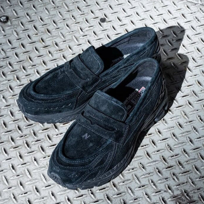 New Balance 1906L Loafer - Black Suede displayed on a textured surface.