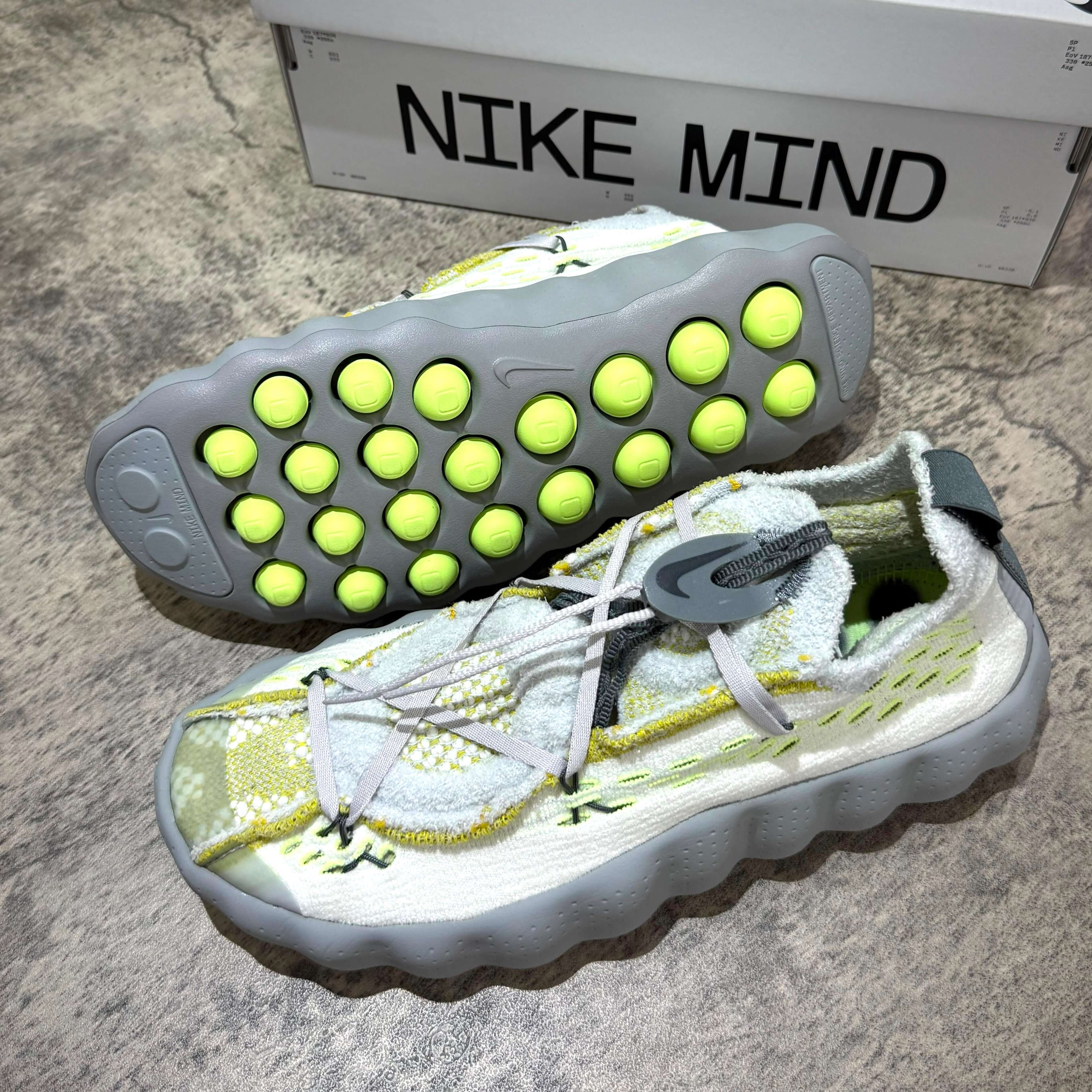 Nike Mind 002 Flyknit - Wolf Grey sneaker with unique sole design and vibrant details.