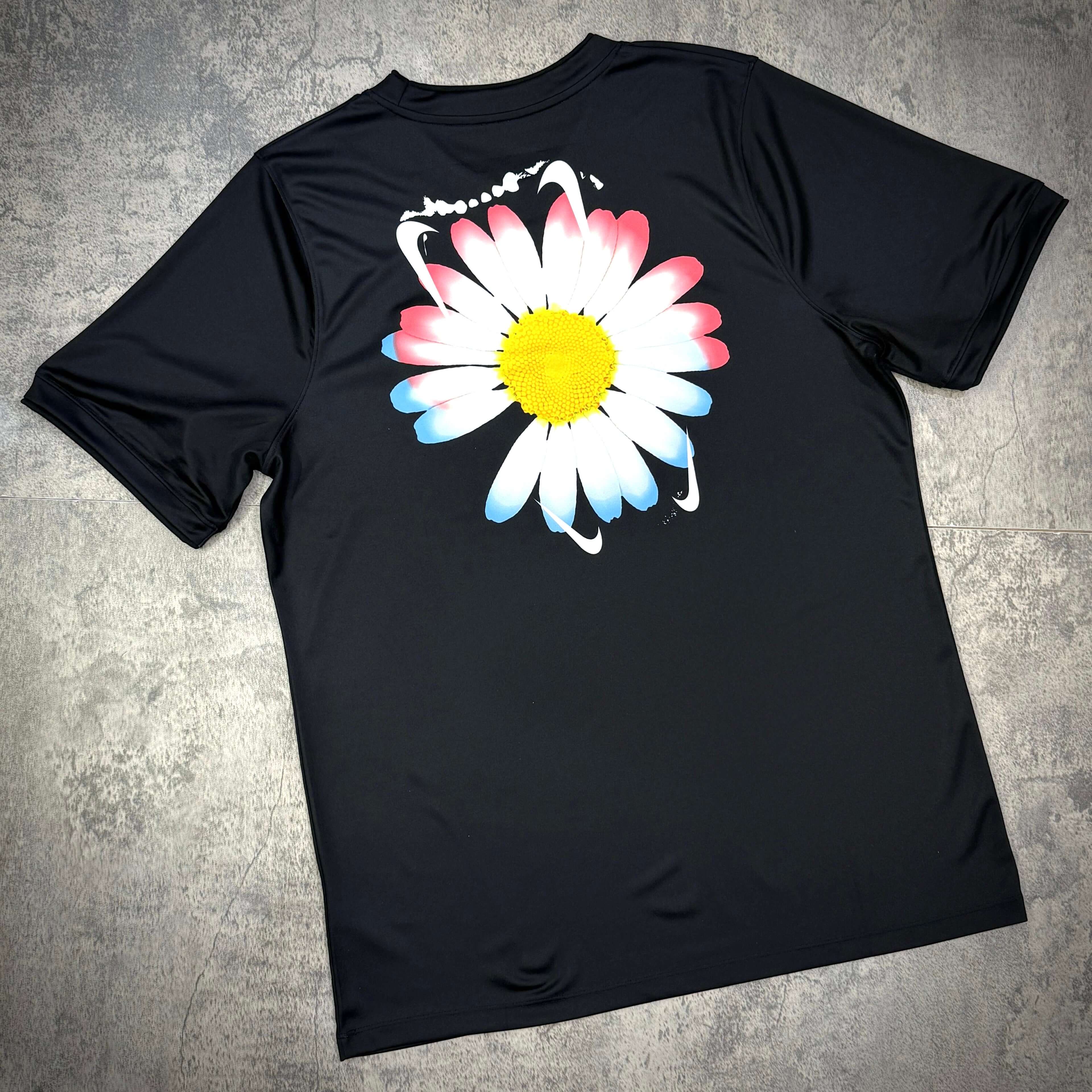 Black football top featuring a colorful daisy graphic on the back, part of the Nike x Peaceminusone x Korea KFA Academy collection.