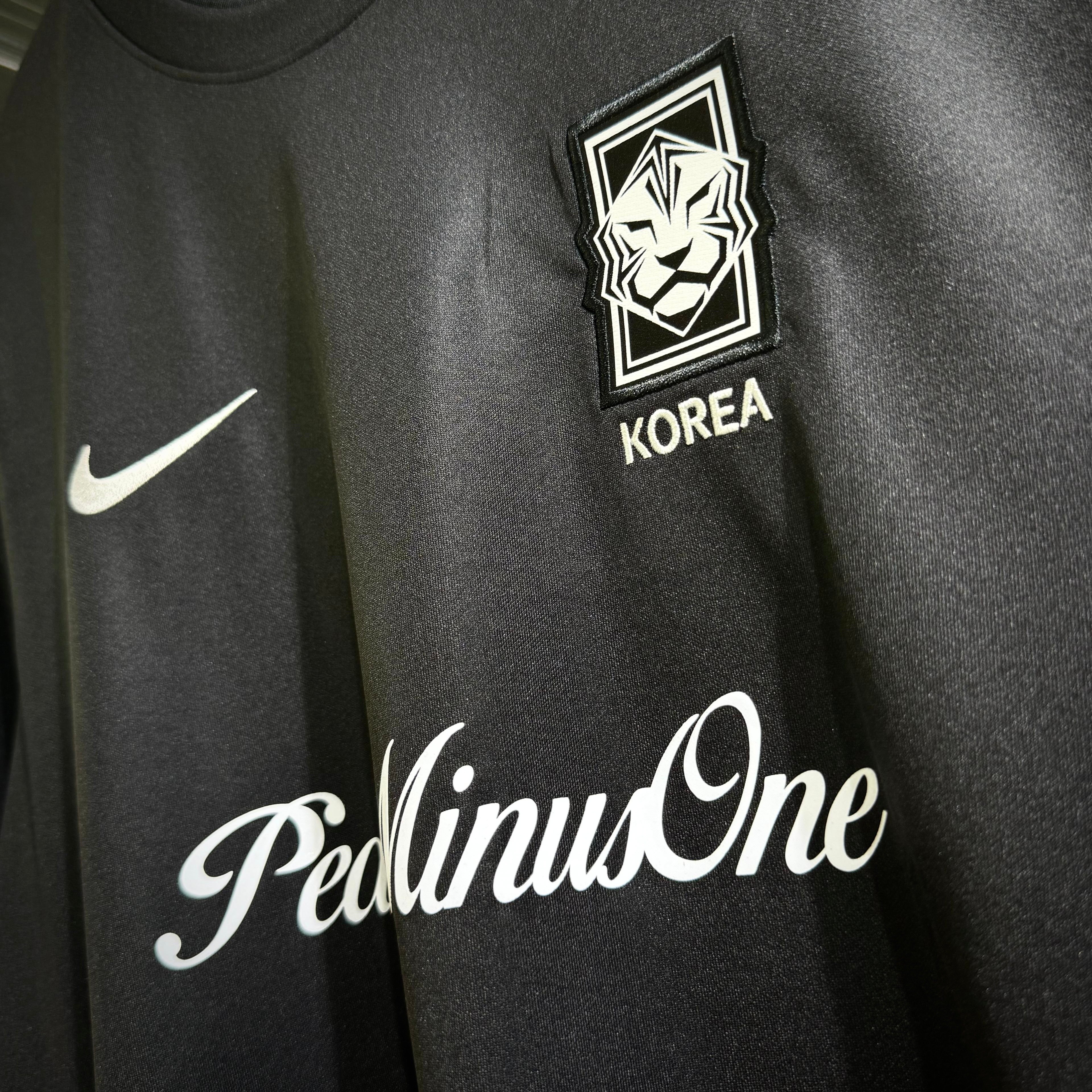 Close-up of Nike x Peaceminusone Korea football top featuring logo and design details.