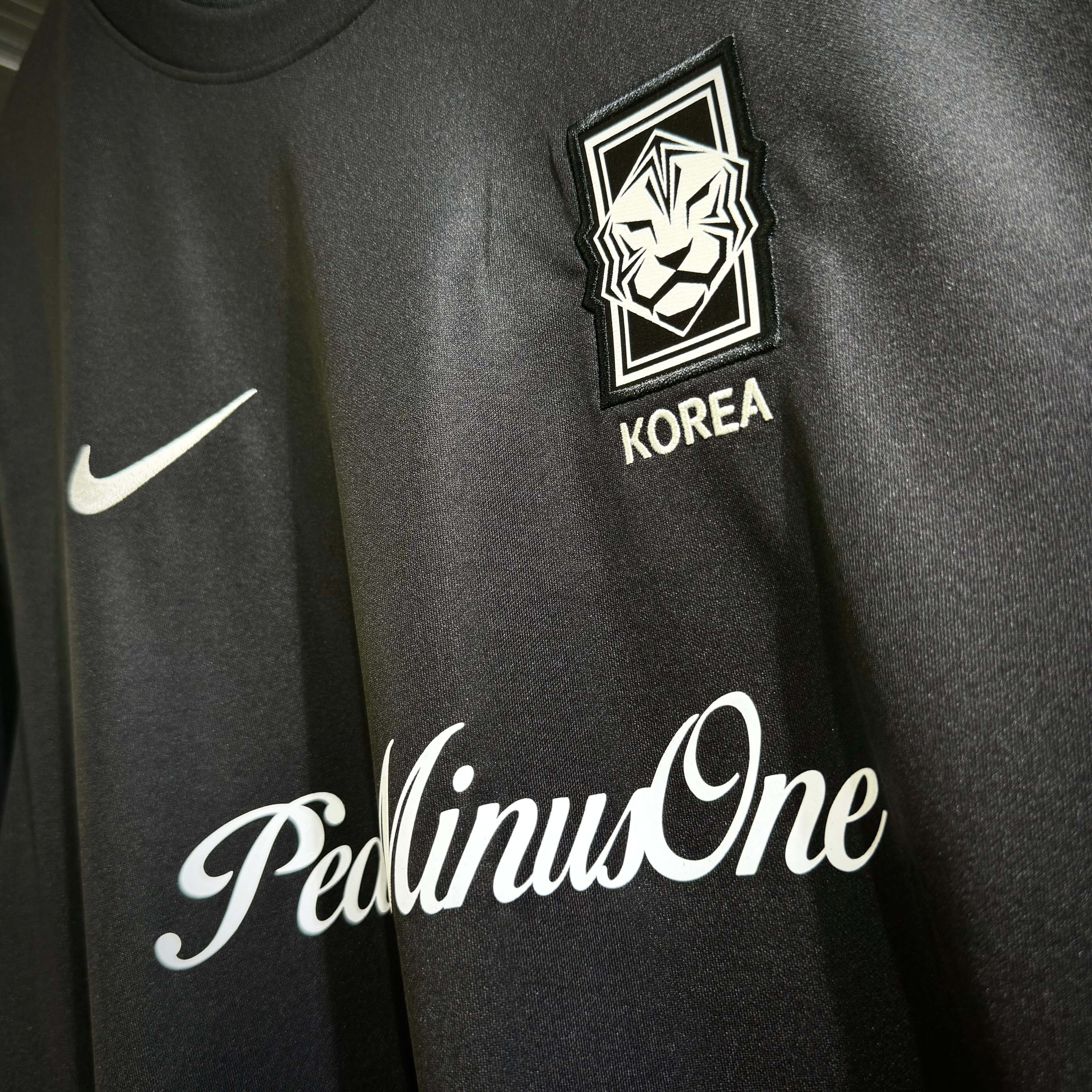Close-up of Nike x Peaceminusone Korea football top featuring logo and design details.