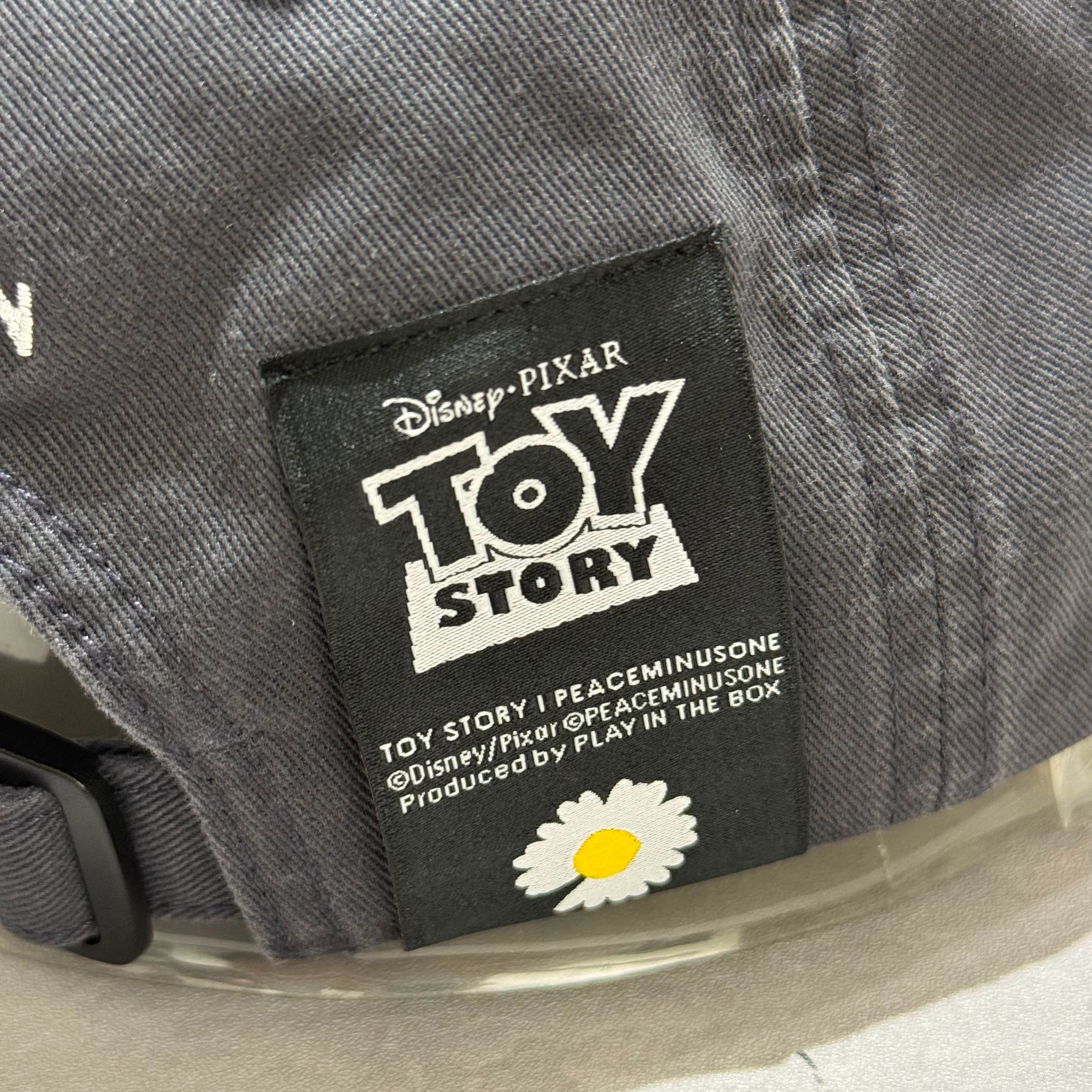 Label of PEACEMINUSONE x Toy Story The First Fan - Cap 01 showcasing Toy Story branding and production details.
