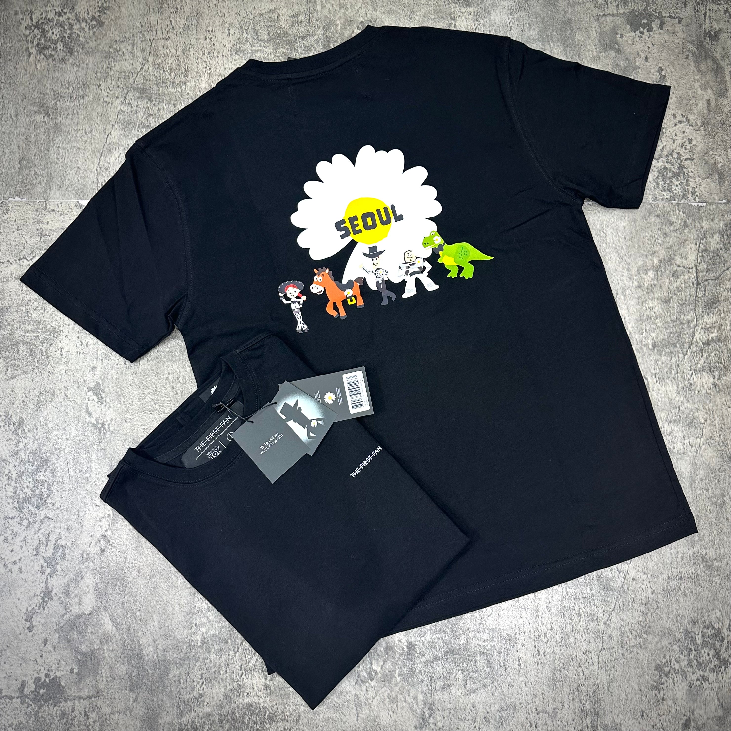 PEACEMINUSONE x Toy Story The First Fan - T-Shirt featuring colorful graphics and 'SEOUL' text on the back.