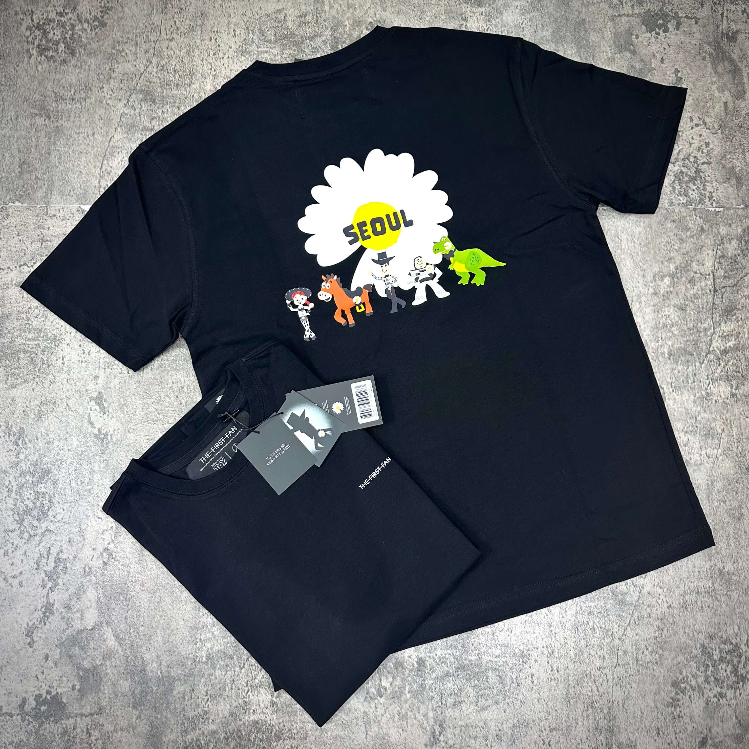 PEACEMINUSONE x Toy Story The First Fan - T-Shirt featuring colorful graphics and 'SEOUL' text on the back.