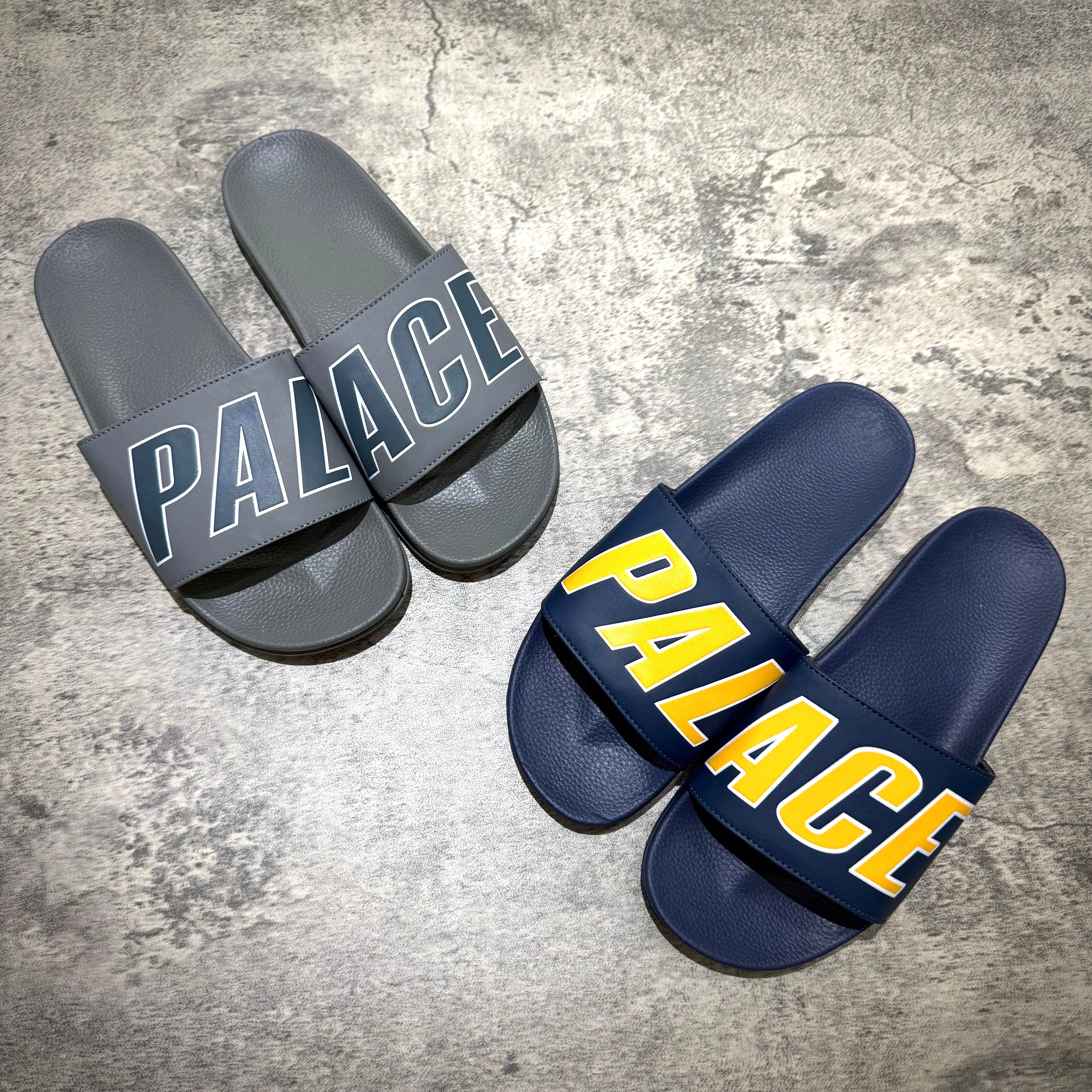 Palace Slider - Navy / Grey slip-on sandals with bold branding displayed on straps.