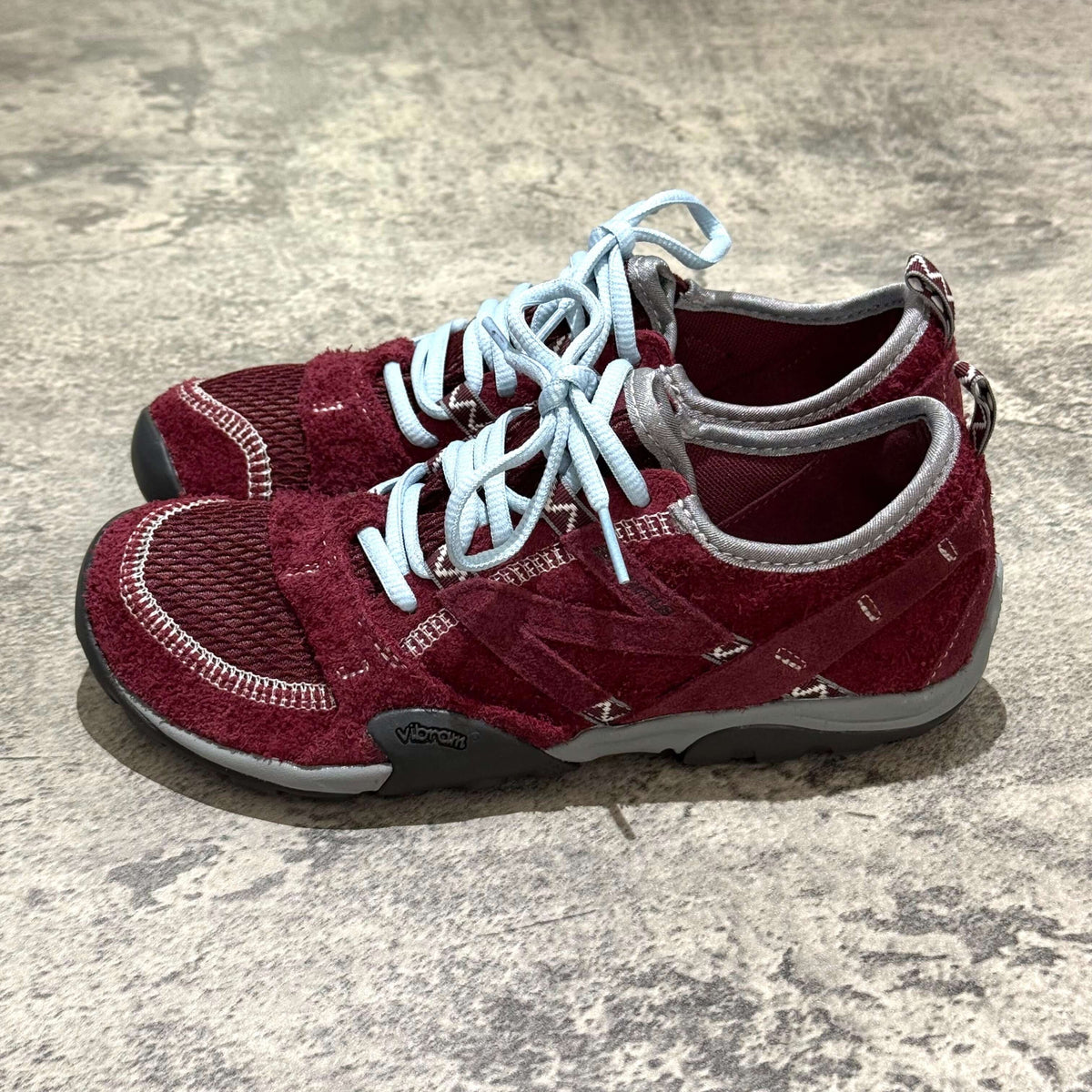 SUNLOVETOUR x New Balance MT1001ND shoes featuring a unique burgundy design with light blue laces.