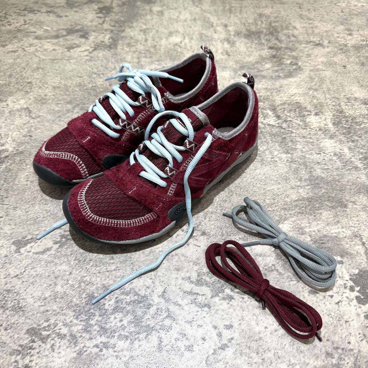 SUNLOVETOUR x New Balance MT1001ND in red with light blue laces and extra lace options.