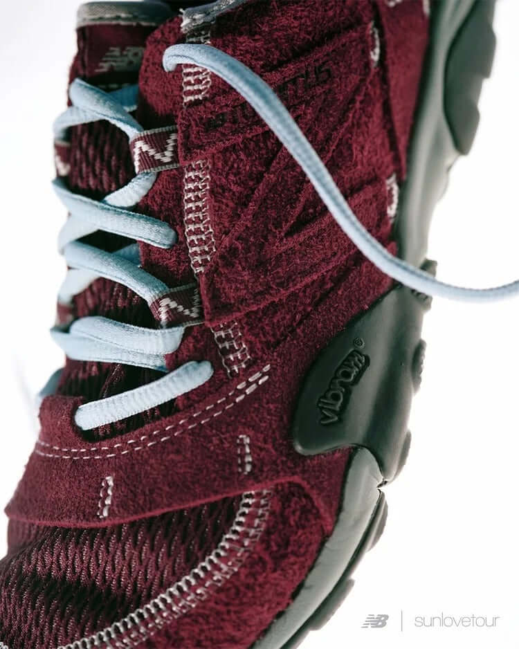 Close-up of SUNLOVETOUR x New Blance MT1001ND shoe showcasing burgundy color and light blue laces.