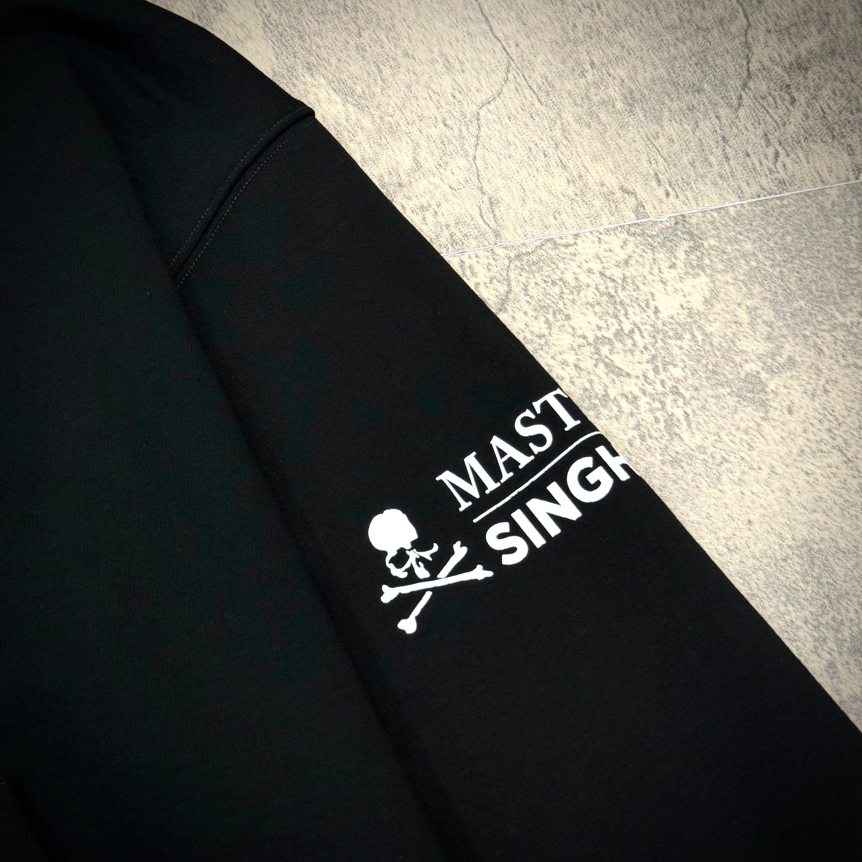 Close-up of the Singha Soda x Mastermind World Zip Up Hoodie showcasing the iconic Mastermind logo on the sleeve.