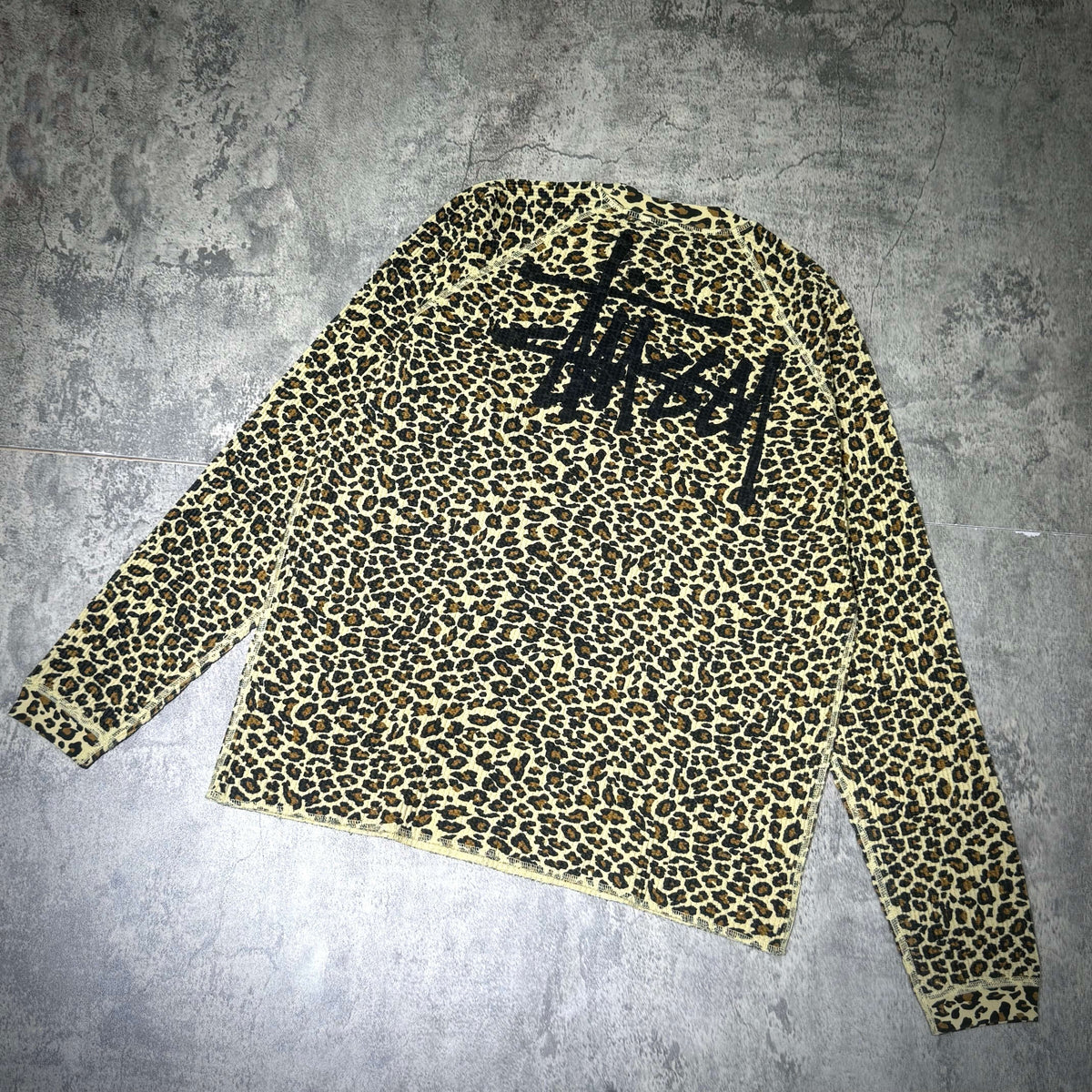 Stussy Basic Raglan Thermal LS Crew FW26 in leopard print with black logo on back, long sleeve style.