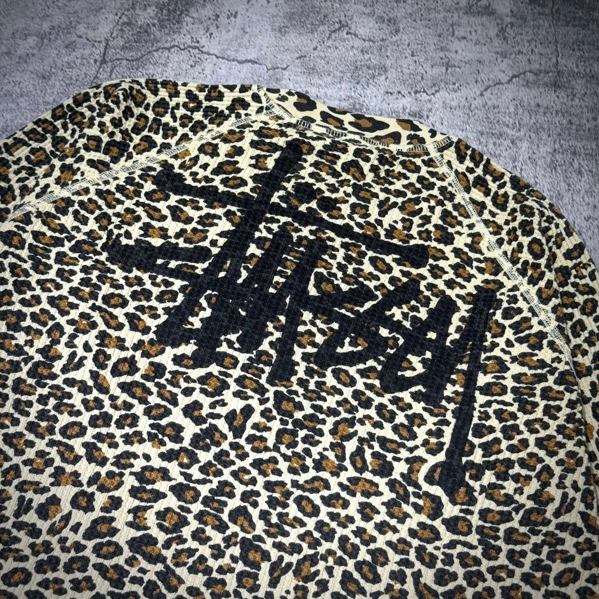 Stussy Basic Raglan Thermal LS Crew FW26 featuring a leopard print design and bold logo detail.