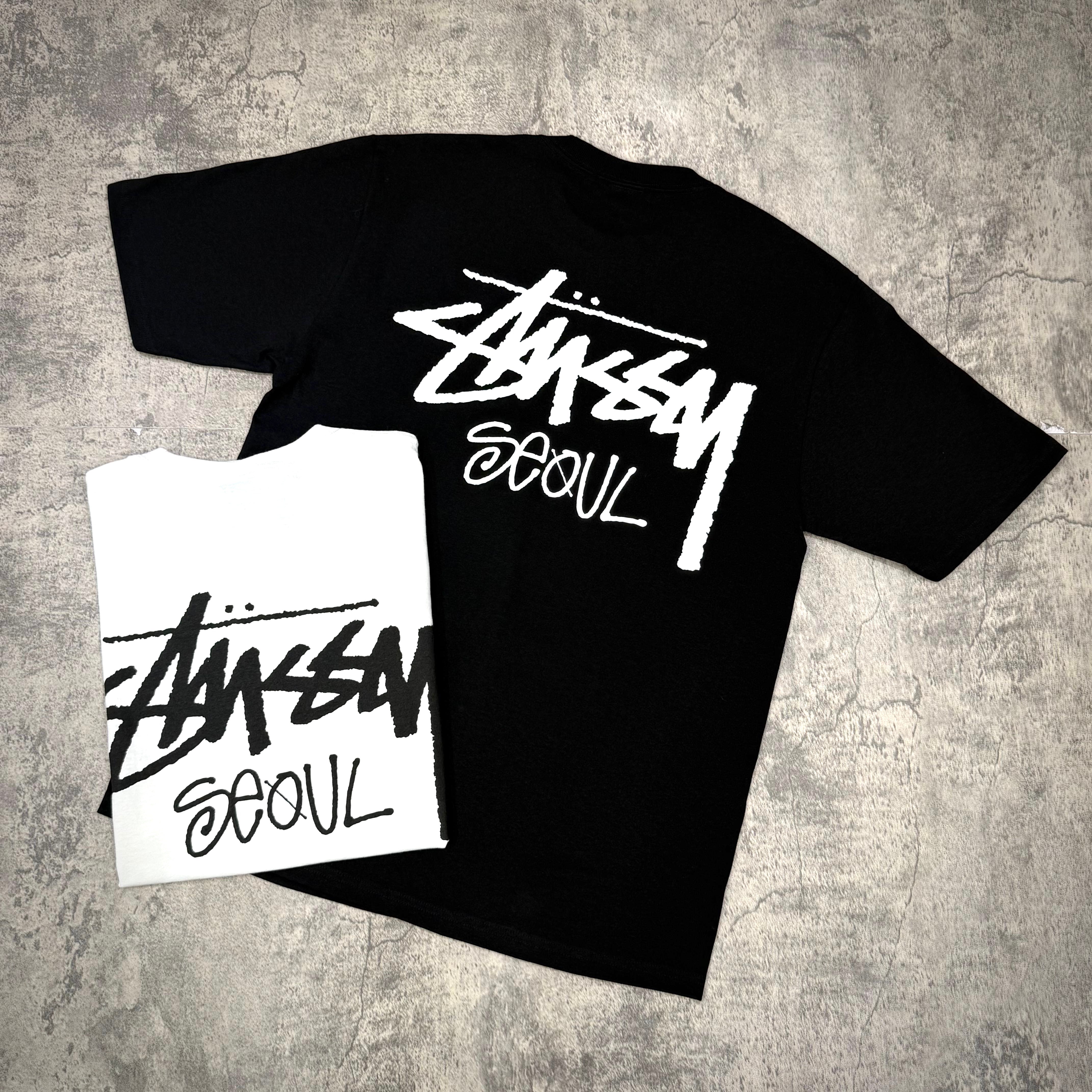 Stussy Seoul Exclusive Logo Tee in black and white, showcasing unique back design and bold branding.