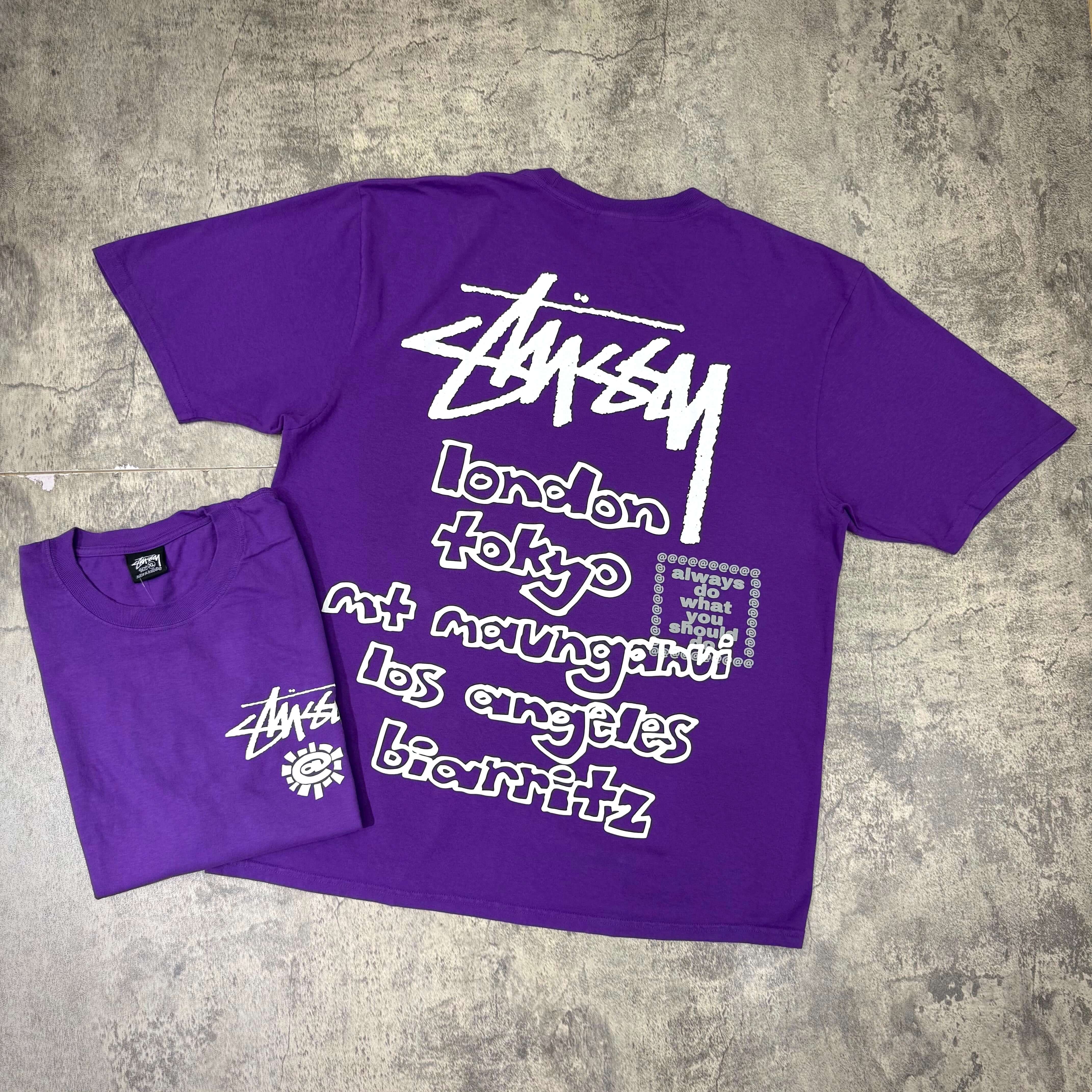 Stussy x Always Do What You Should Do World Tour Tee in purple, featuring city names on the back.