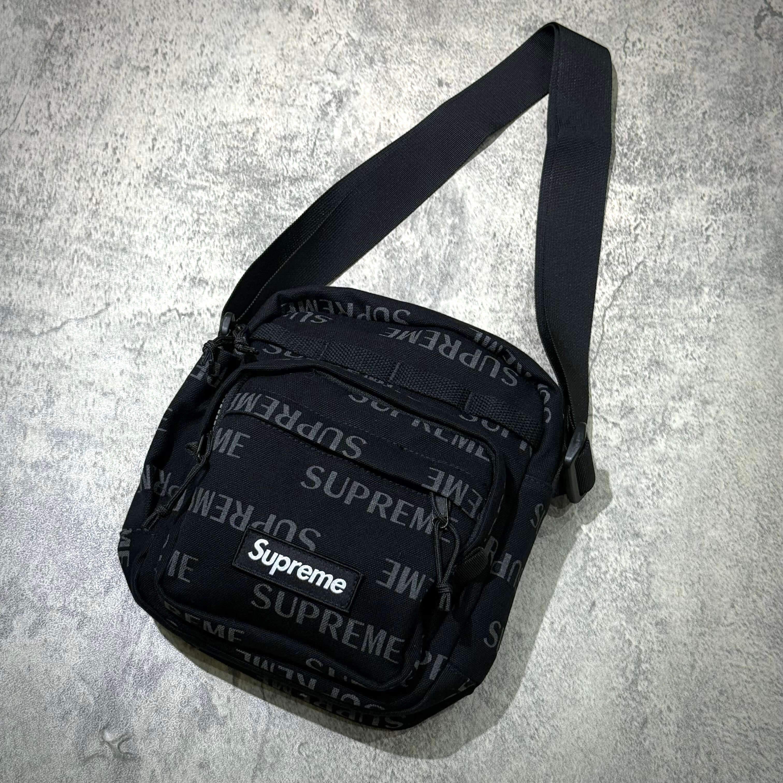 Supreme FW26 Shoulder Bag featuring a sleek black design with repeating Supreme logo pattern.