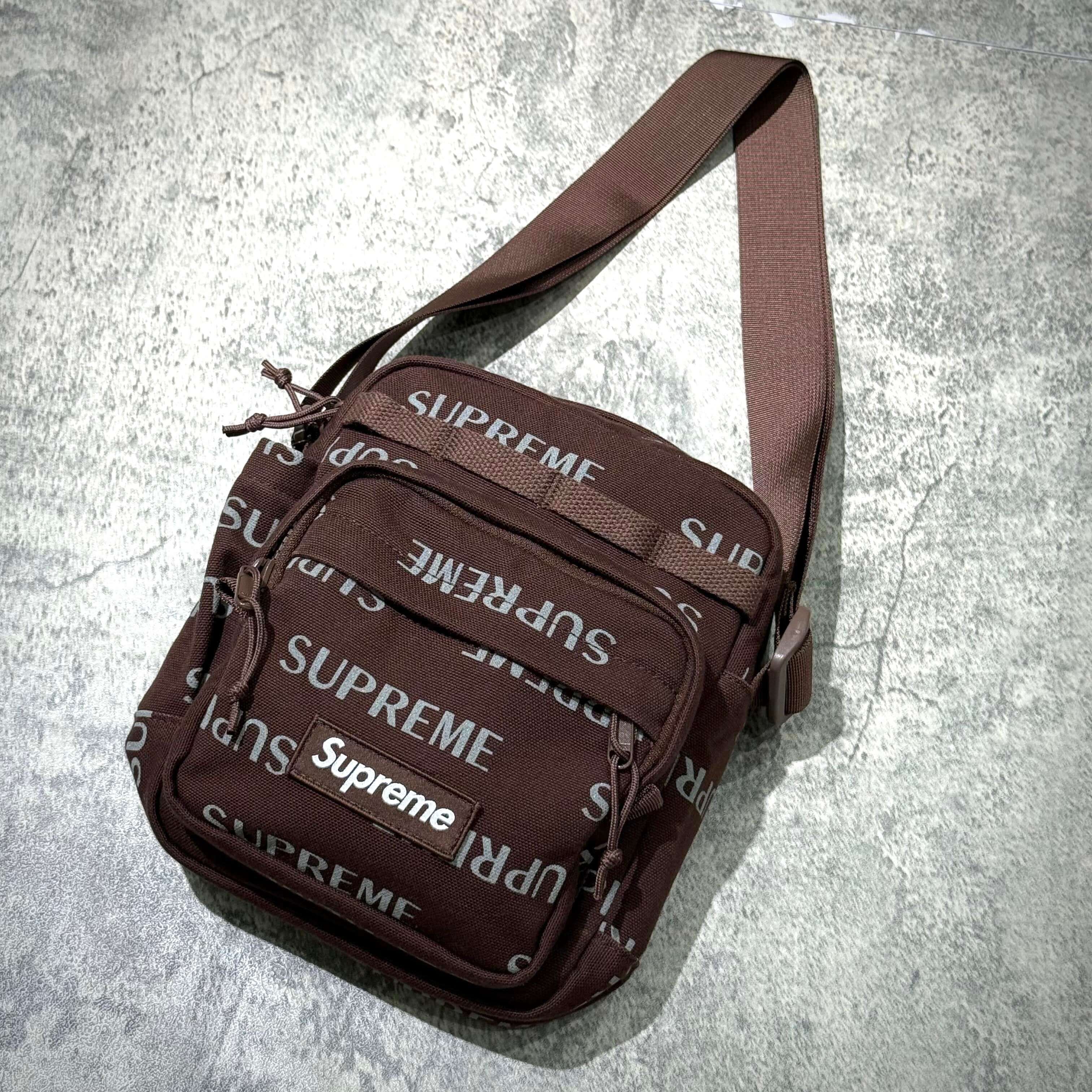 Supreme FW26 Shoulder Bag in brown featuring repeated logo design and adjustable strap.
