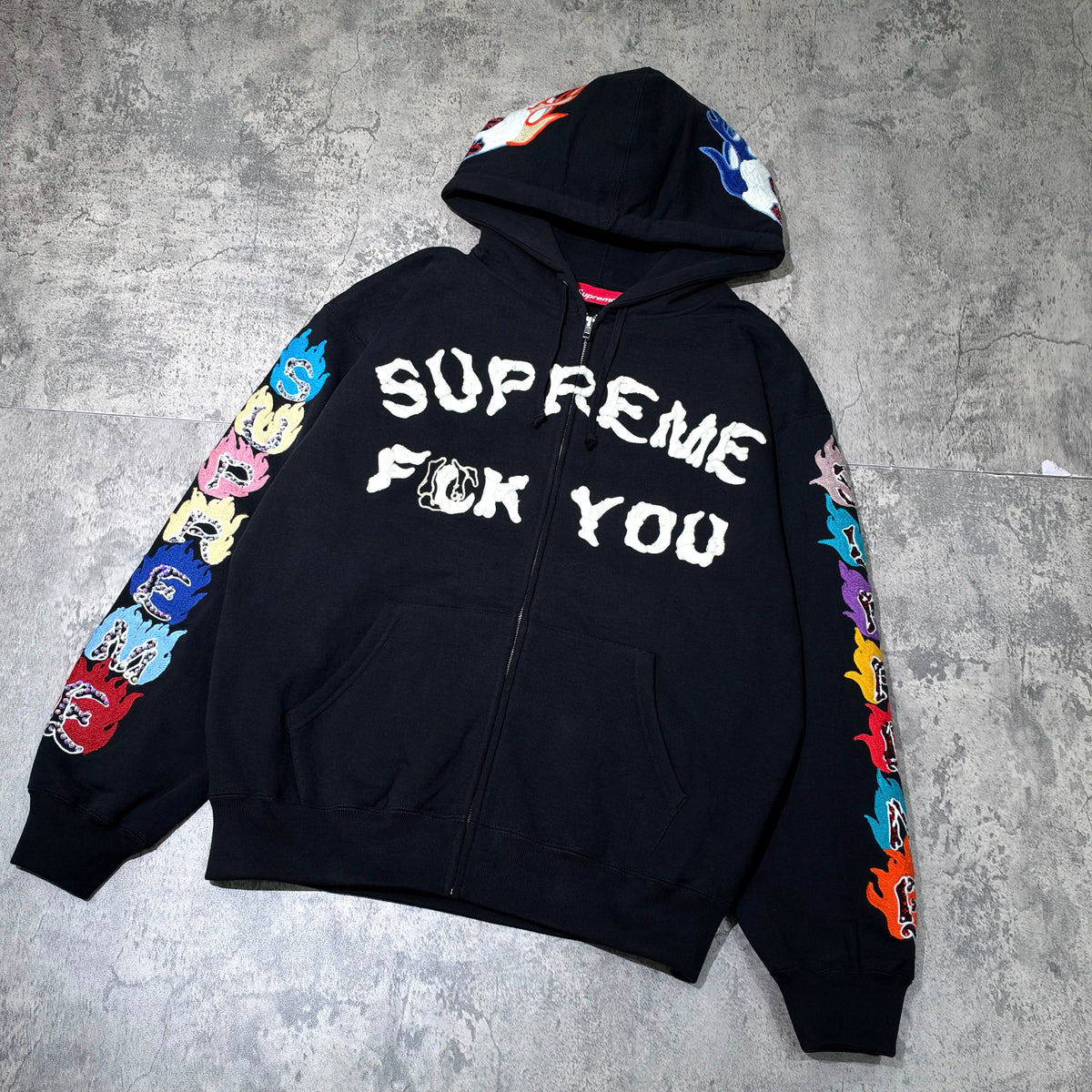 Supreme Fuck You Zip Up Hooded Sweatshirt in black with colorful graphic designs on sleeves.