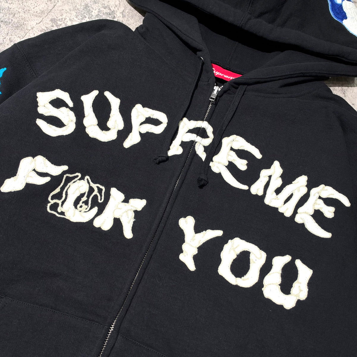 Supreme Fuck You Zip Up Hooded Sweatshirt displayed on a surface with prominent white lettering.