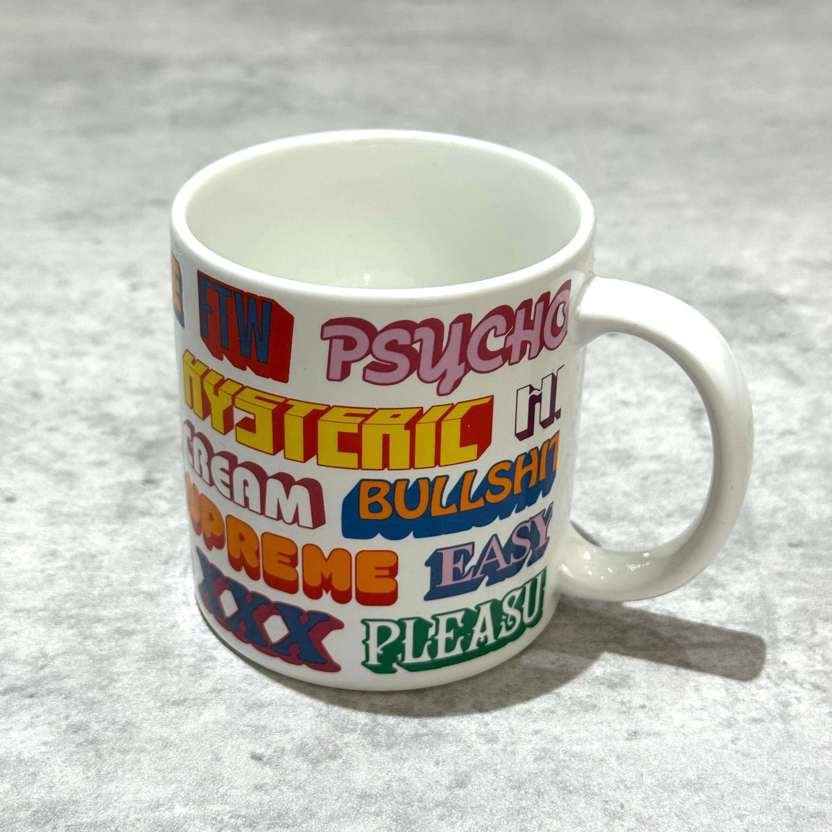 Supreme Hysteric Glamour Ceramic Coffee Mug featuring colorful text prints on a white background.