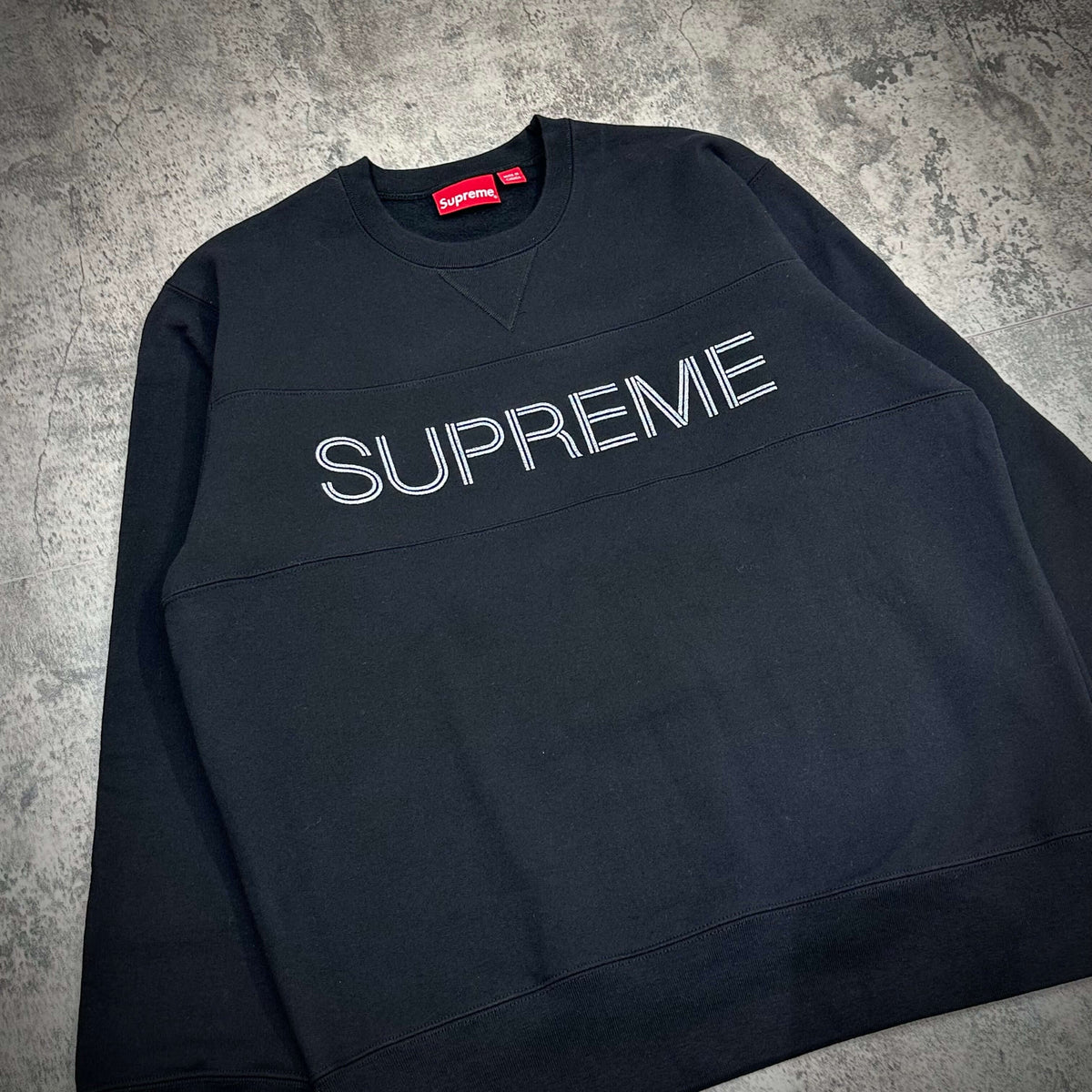 Supreme Zig Zag Stitch Panel Crewneck in black featuring bold SUPREME logo across the chest on a textured background.