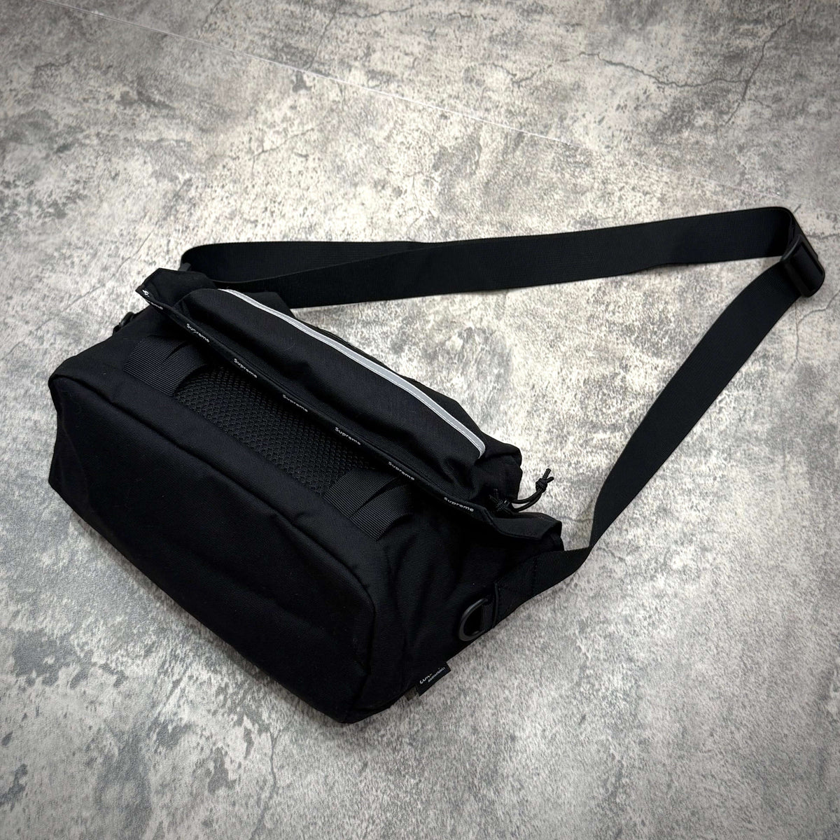 Supreme Messenger Bag FW24 in black with adjustable strap and reflective stripe detail.