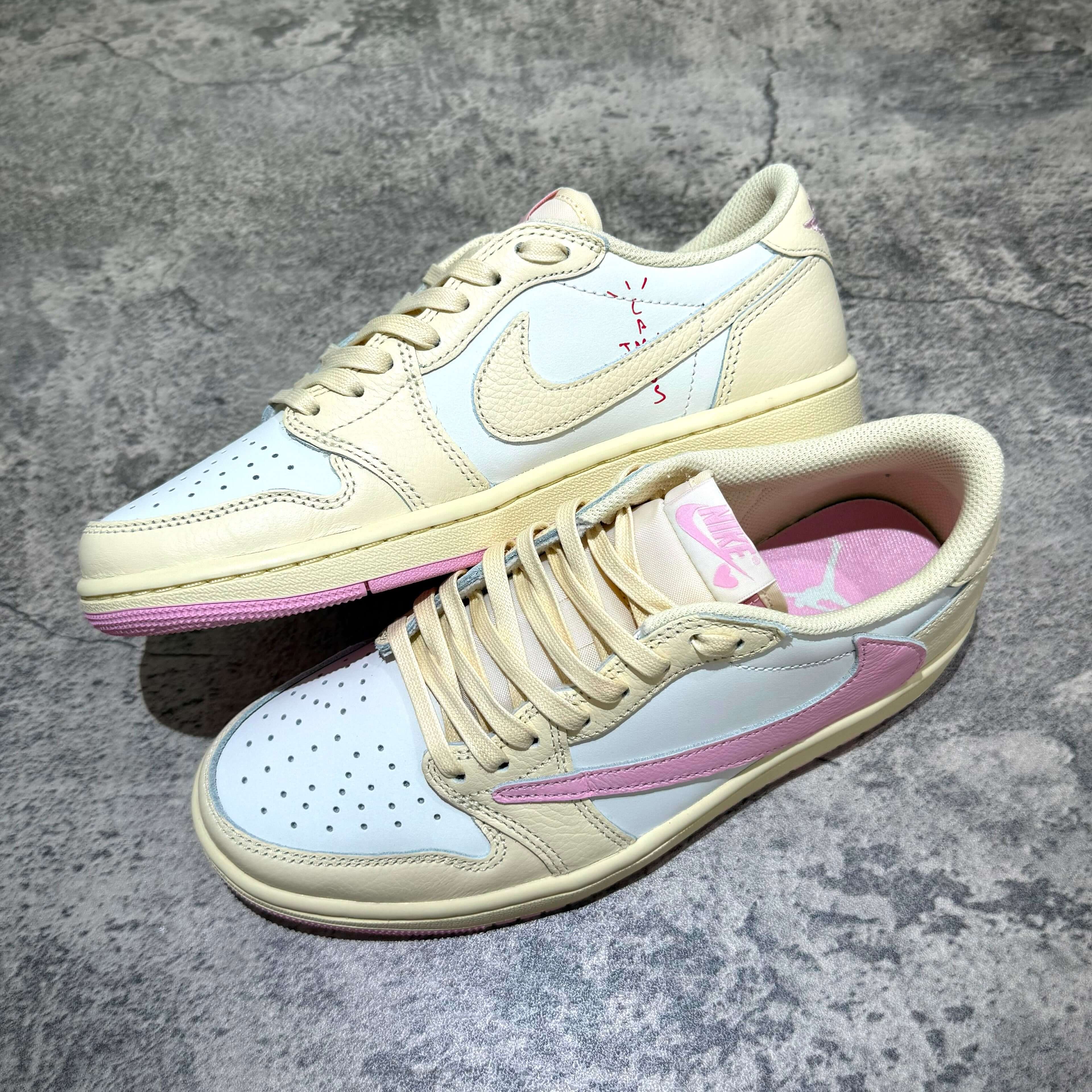 Travis Scott × Nike Air Jordan 1 Retro Low SP - Shy Pink sneaker pair with unique yellow and pink accents.