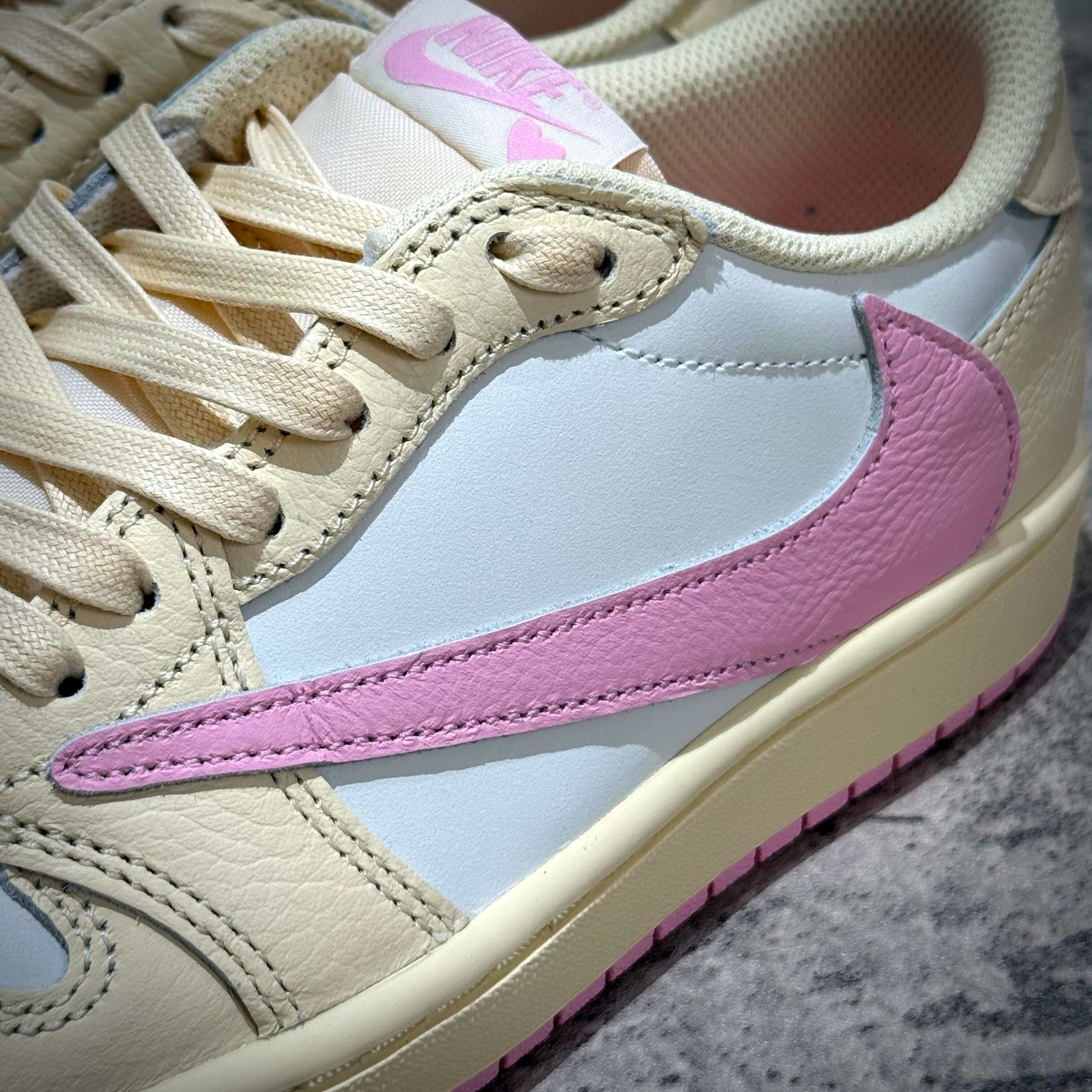 Travis Scott × Nike Air Jordan 1 Retro Low SP - Shy Pink close-up of sneaker's side view showing pink swoosh and cream details.