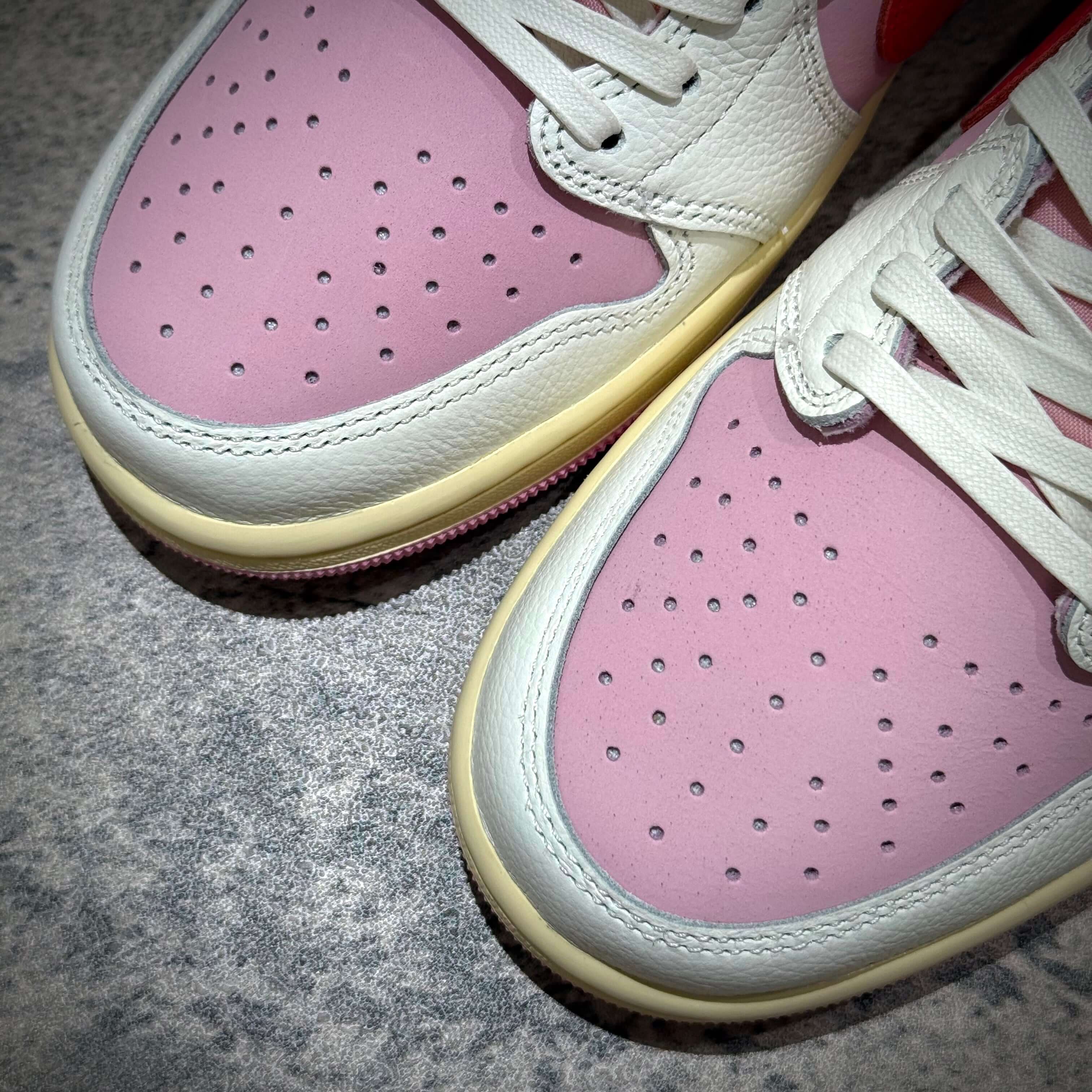 Close-up of Travis Scott × Nike Air Jordan 1 Retro Low SP - Tropical Pink sneakers with pink and white details.