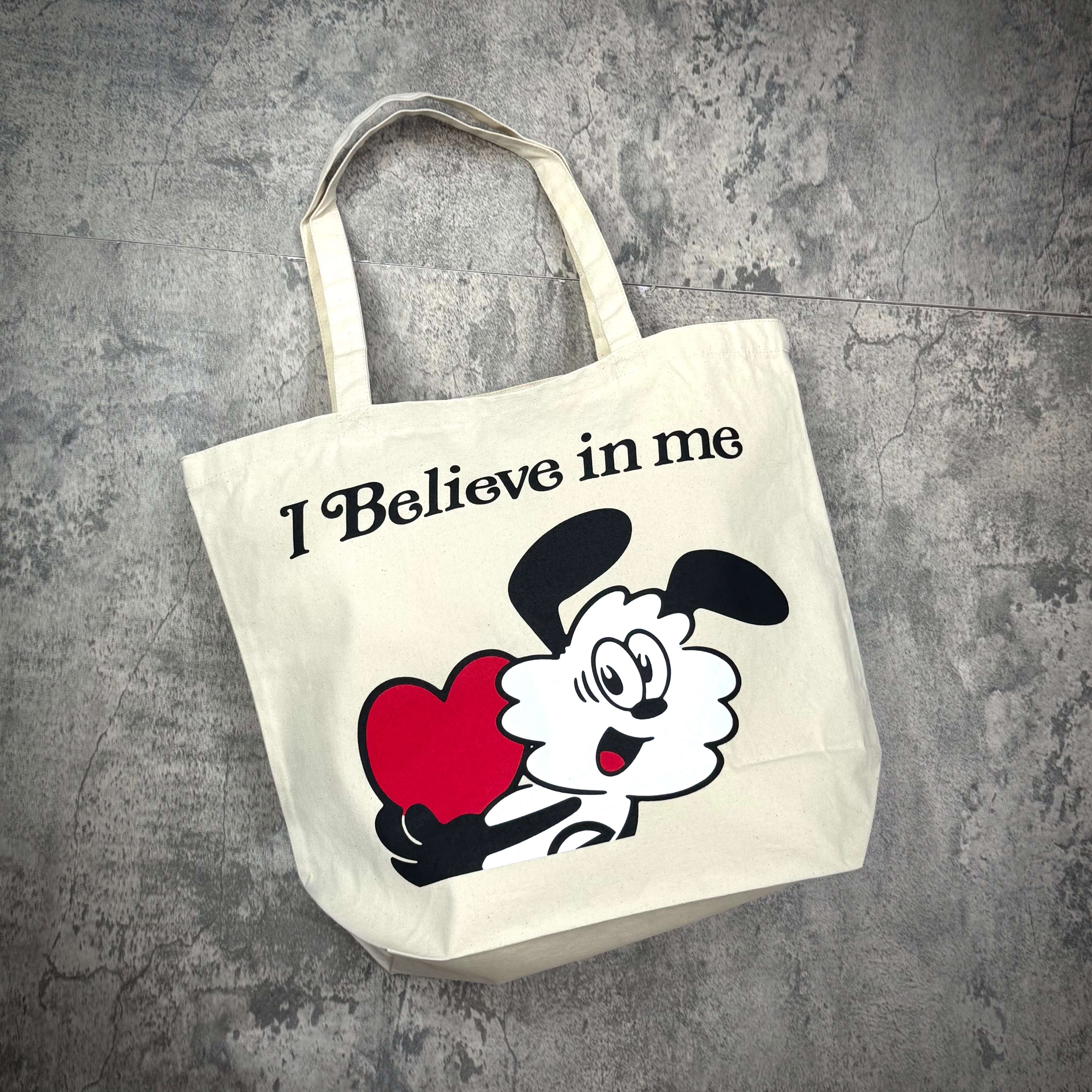 Verdy I Believe in me Tote Bag featuring a playful graphic design of a character holding a heart.