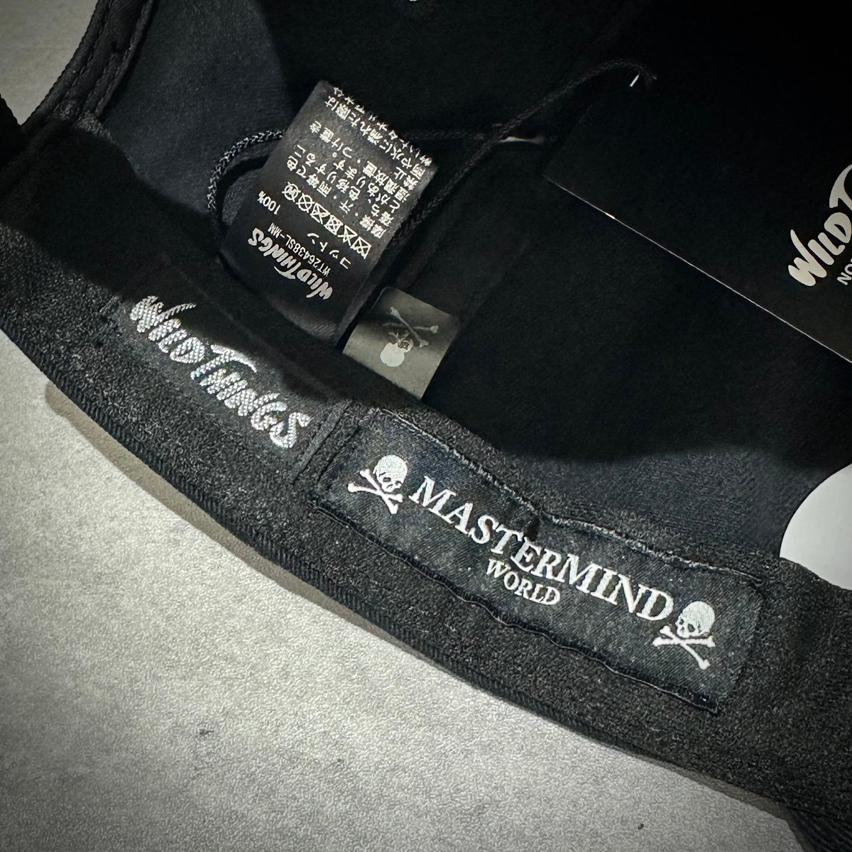 Interior view of Wild Things x Mastermind World Tee Cap showcasing logos and tags.