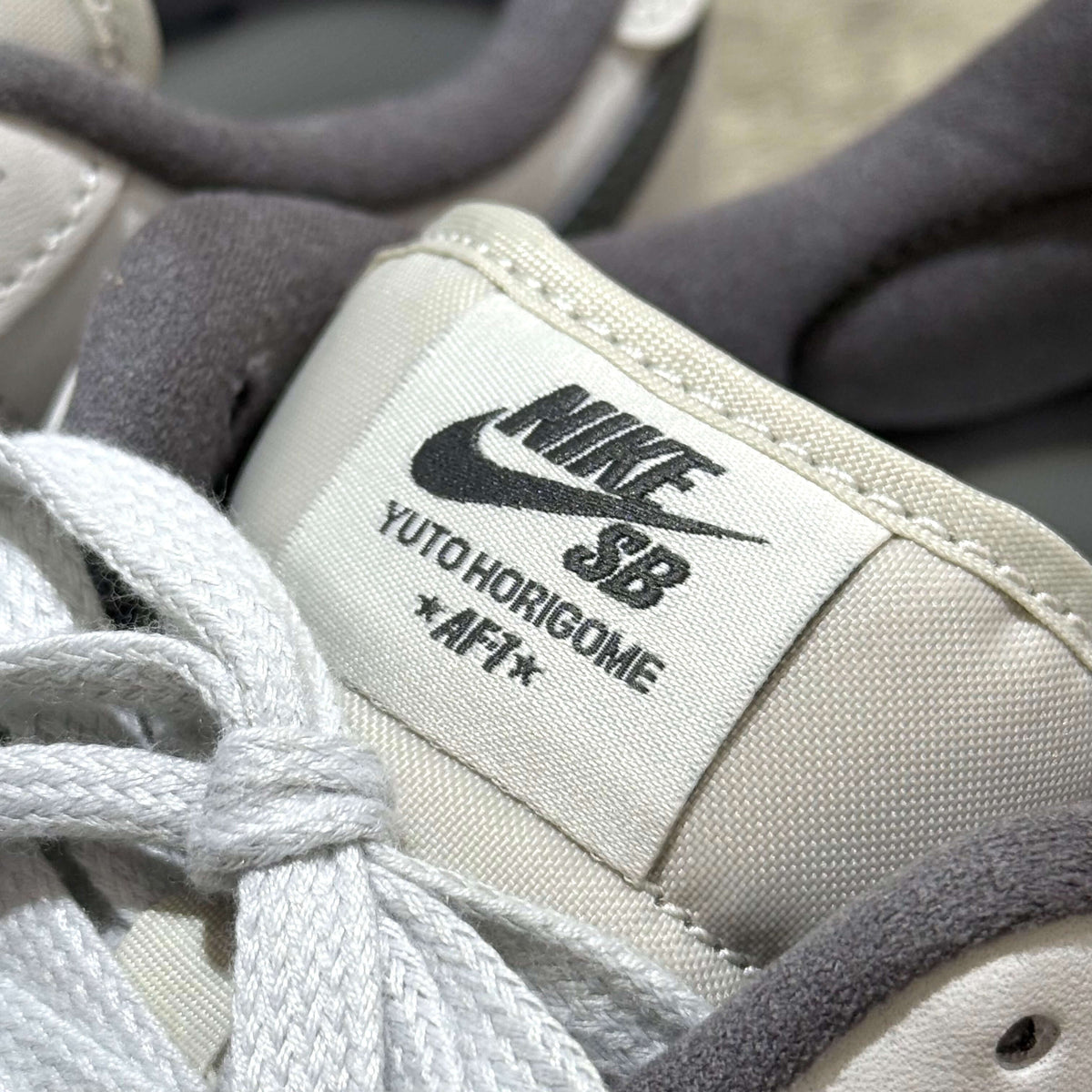 Close-up of Yuto Horigome x Nike SB Air Force 1 Low IO8439-100 shoe tag with logo.