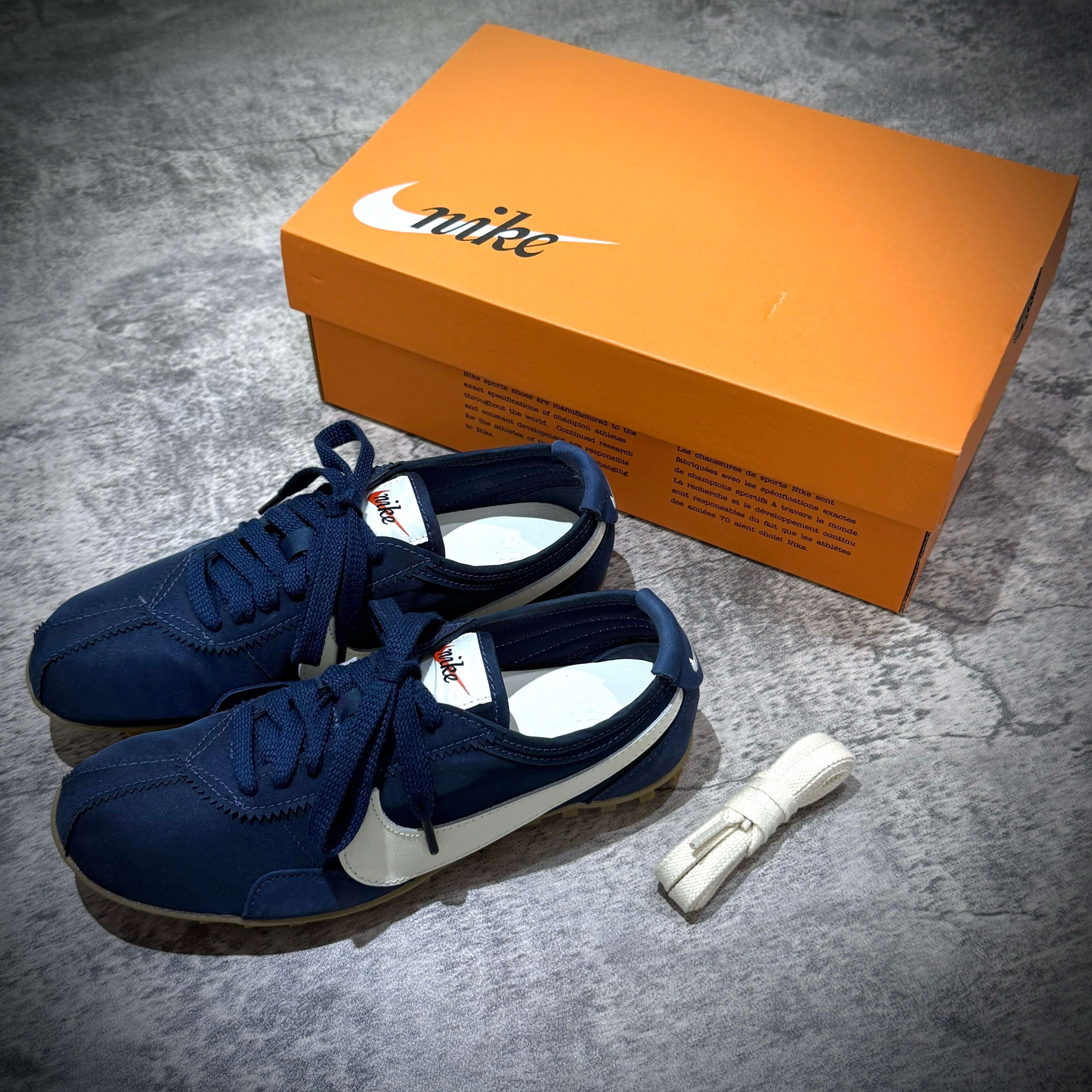 Nike Moon Shoe OG in Midnight Navy colorway with box and extra laces on a gray surface.