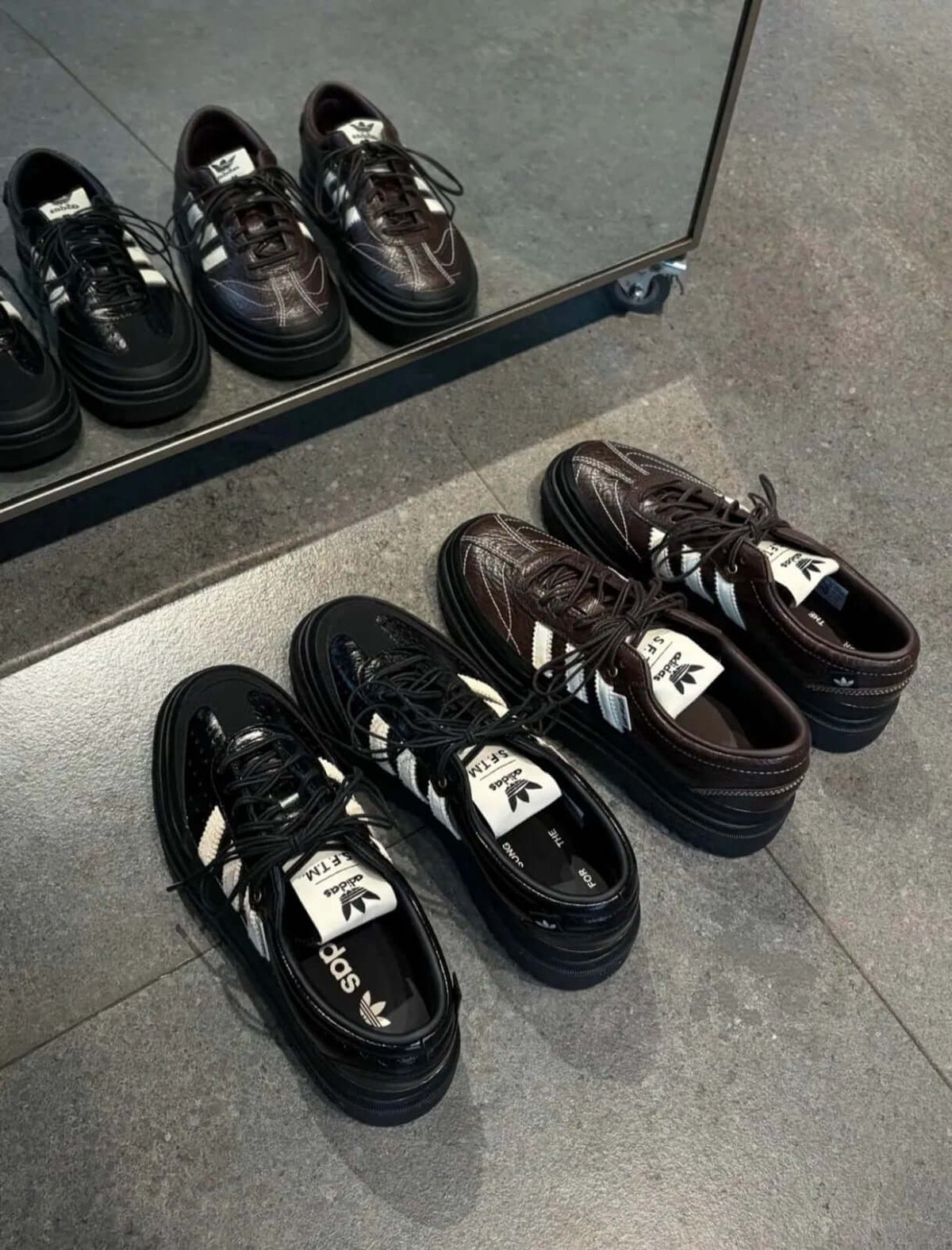 adidas Samba LX Freizeit x Song For The Mute 黑色與棕色運動鞋展示在鏡子前的照片