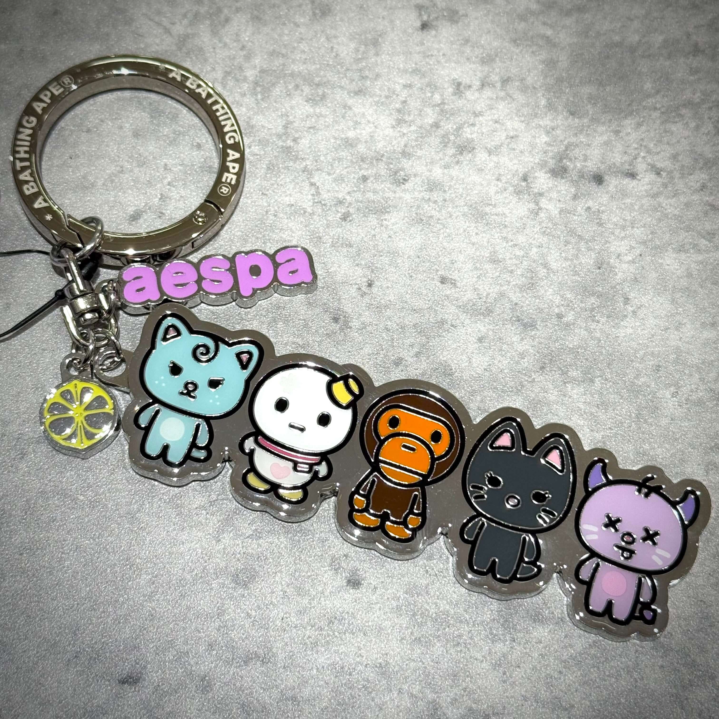 aespa x BAPE Metal Keychain featuring colorful cartoon characters and keyring design.