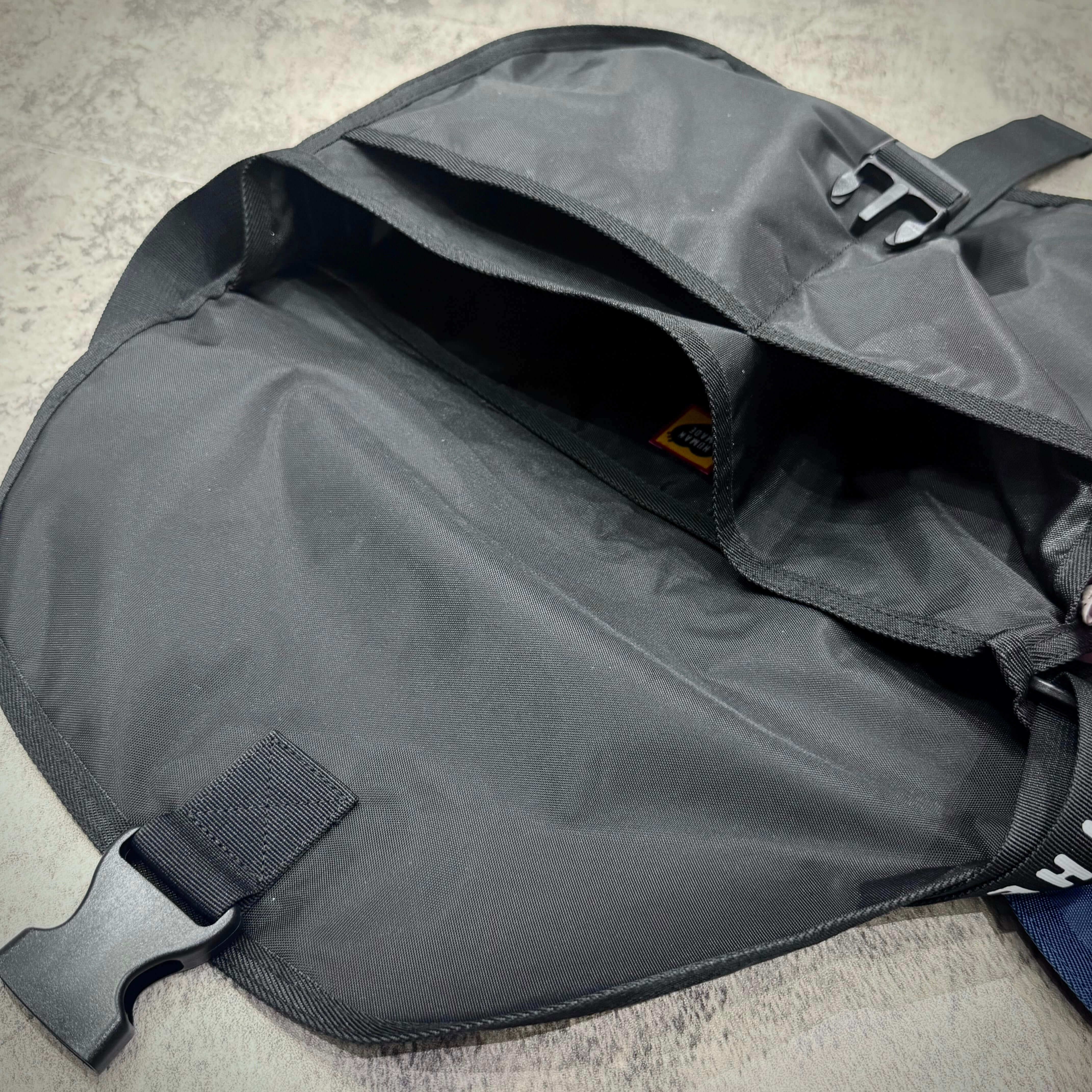 Interior view of Human Made Nylon Shoulder Bag showing spacious compartment and buckle closure.