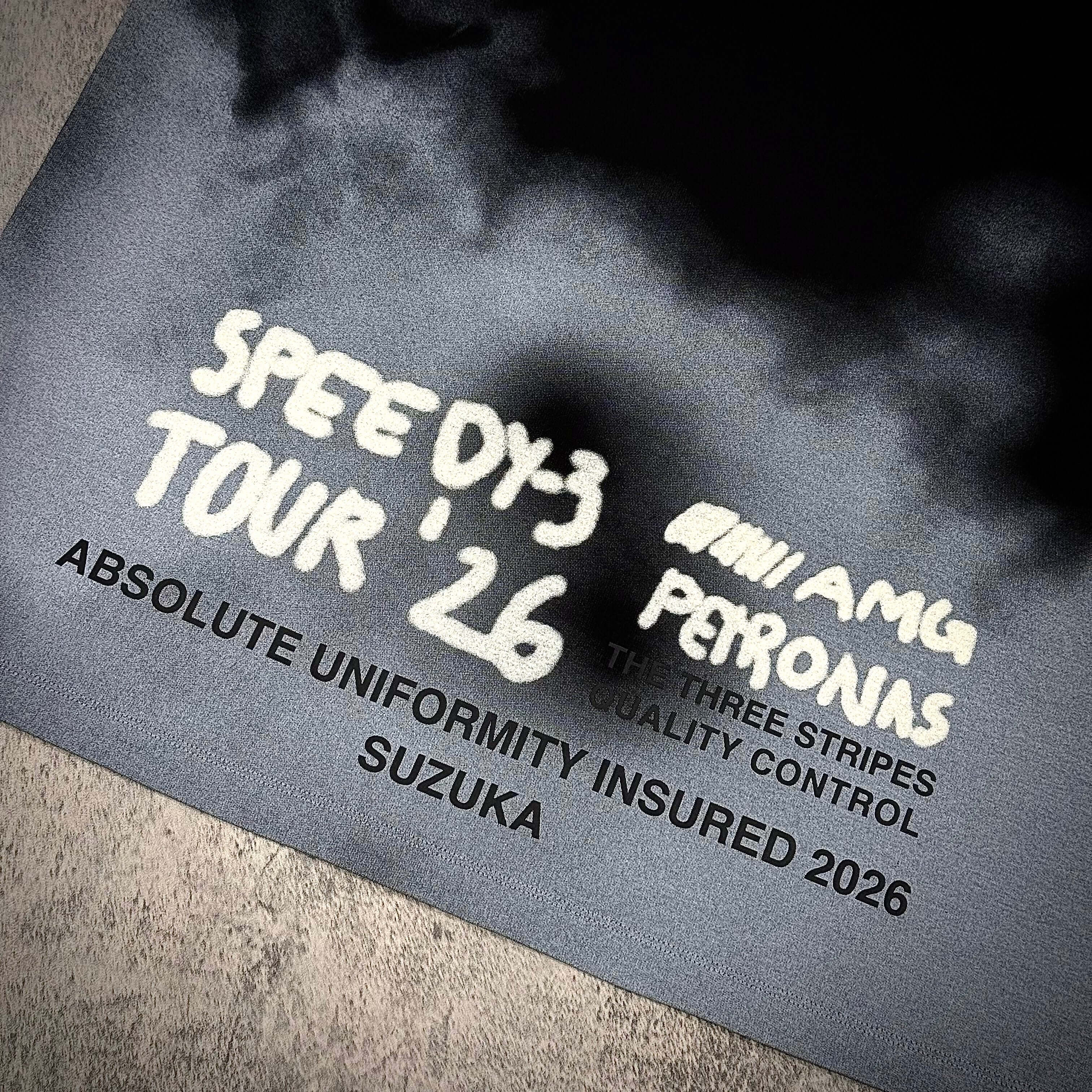 Close-up of Y-3 x Mercedes AMG Petronas F1 Tour Tee design featuring text and logo details.